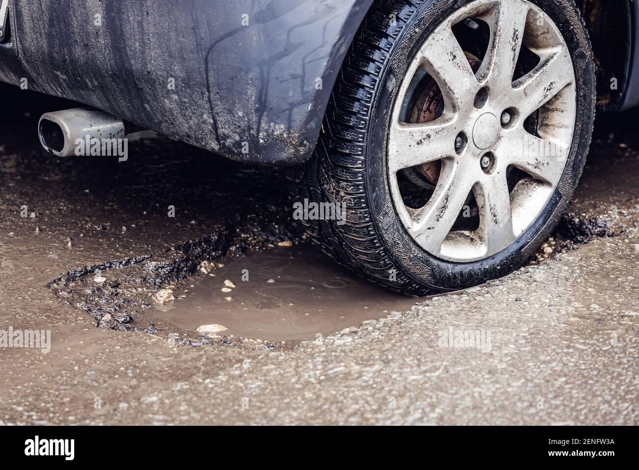 car tire in big pothole on the road Stock Photo