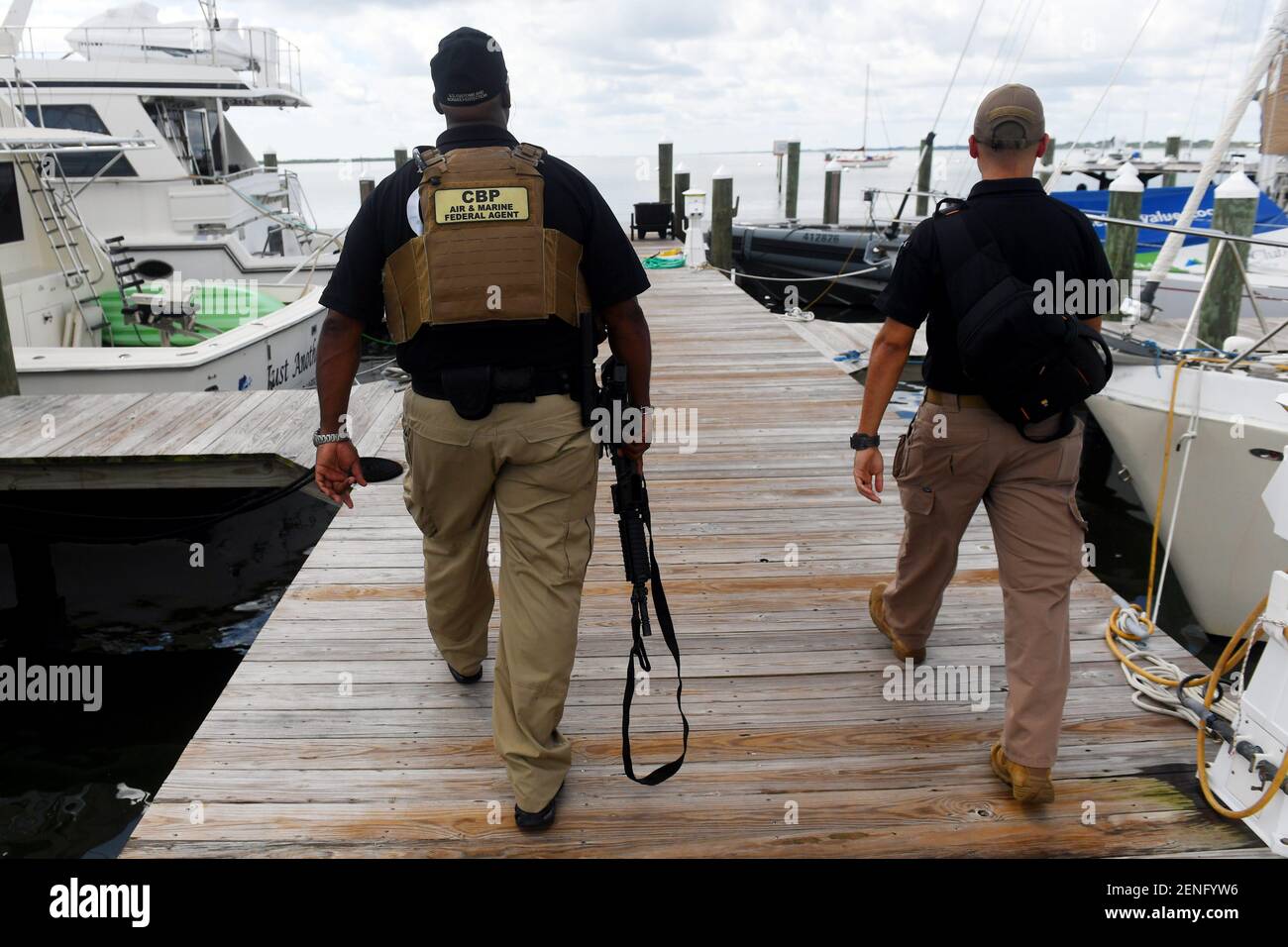 Clean Arrington (left), a marine interdiction agent with the U.S. Customs and Border Protection's Air and Marine Operations section in Fort Pierce, and Ozzy Trevino, a visual information and public affairs officer, make their way to a new 41-foot aluminum boat docked at Causeway Cove Marina on Tuesday, Aug. 6, 2019 in Fort Pierce. The new boat, one of two that will patrol the Treasure Coast, is an upgrade from the previous vessel with specialized navigational equipment and maneuverable camera gear. Tcn Customs Boat 02 Clean Arrington (left), a marine interdiction agent with the U.S. Customs an Stock Photo