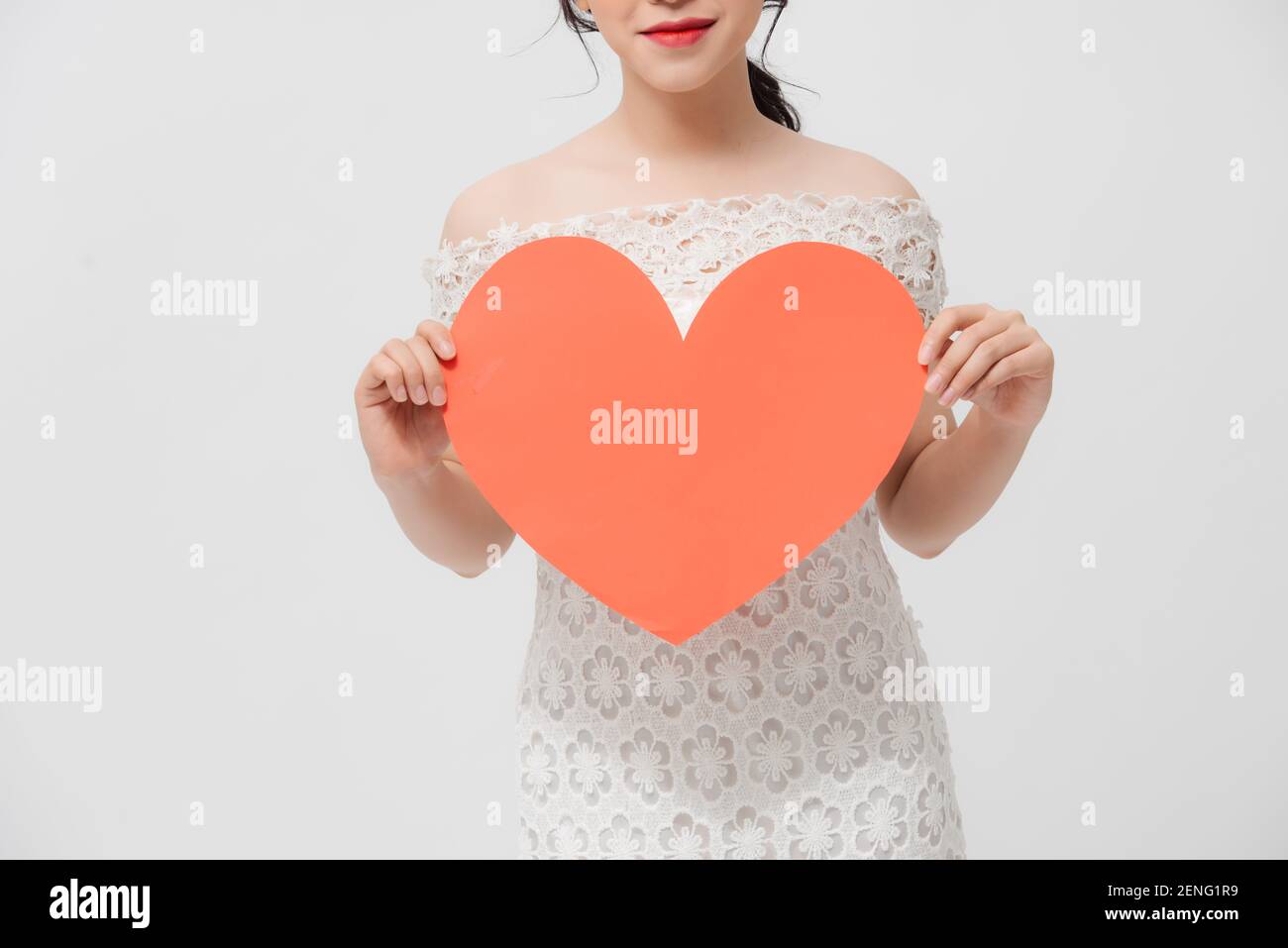 Attractive young Asian woman holding red love shape and standing over ...