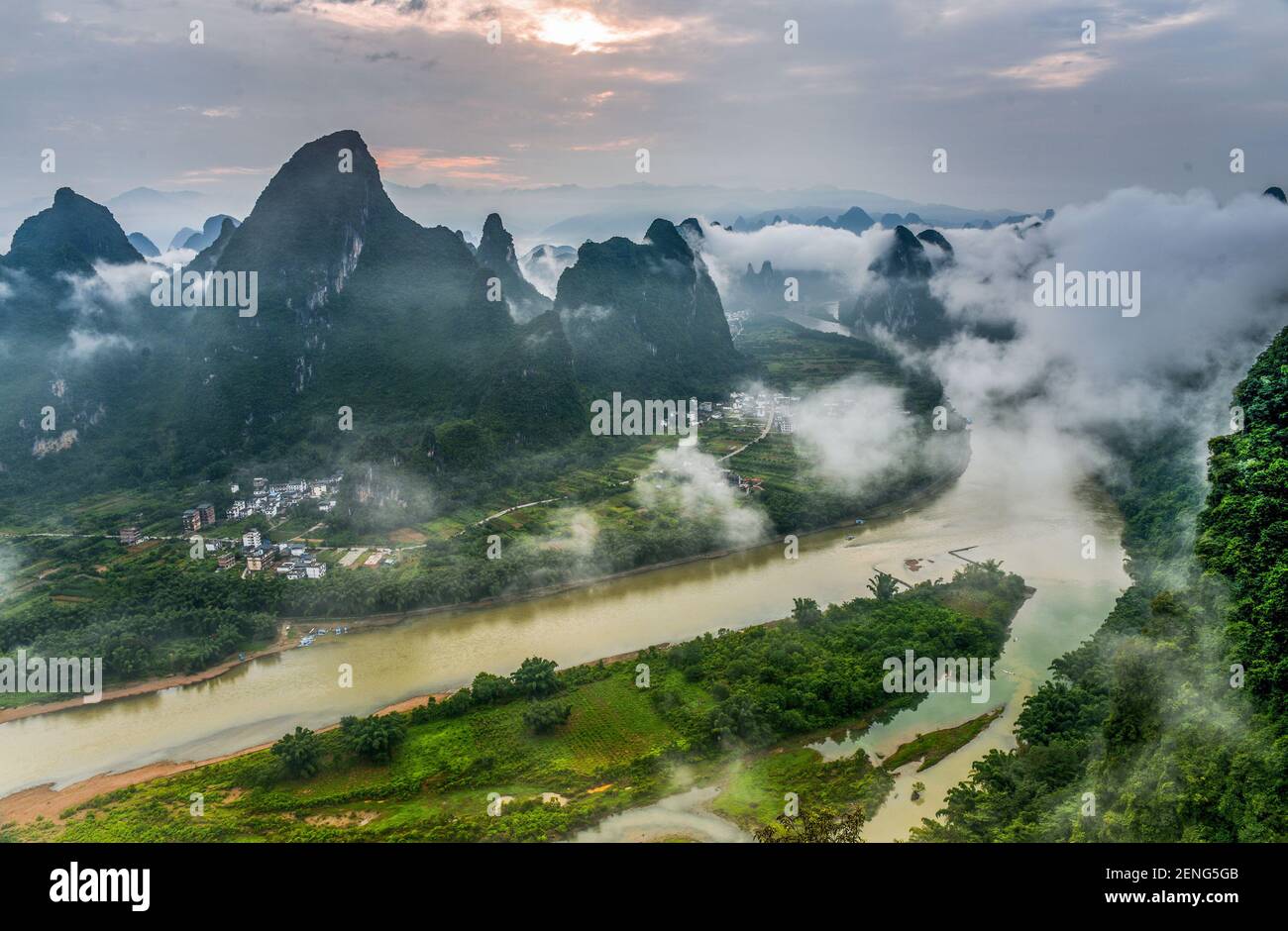 The mountains and hills are surrounded by mist and cloud along the Li ...