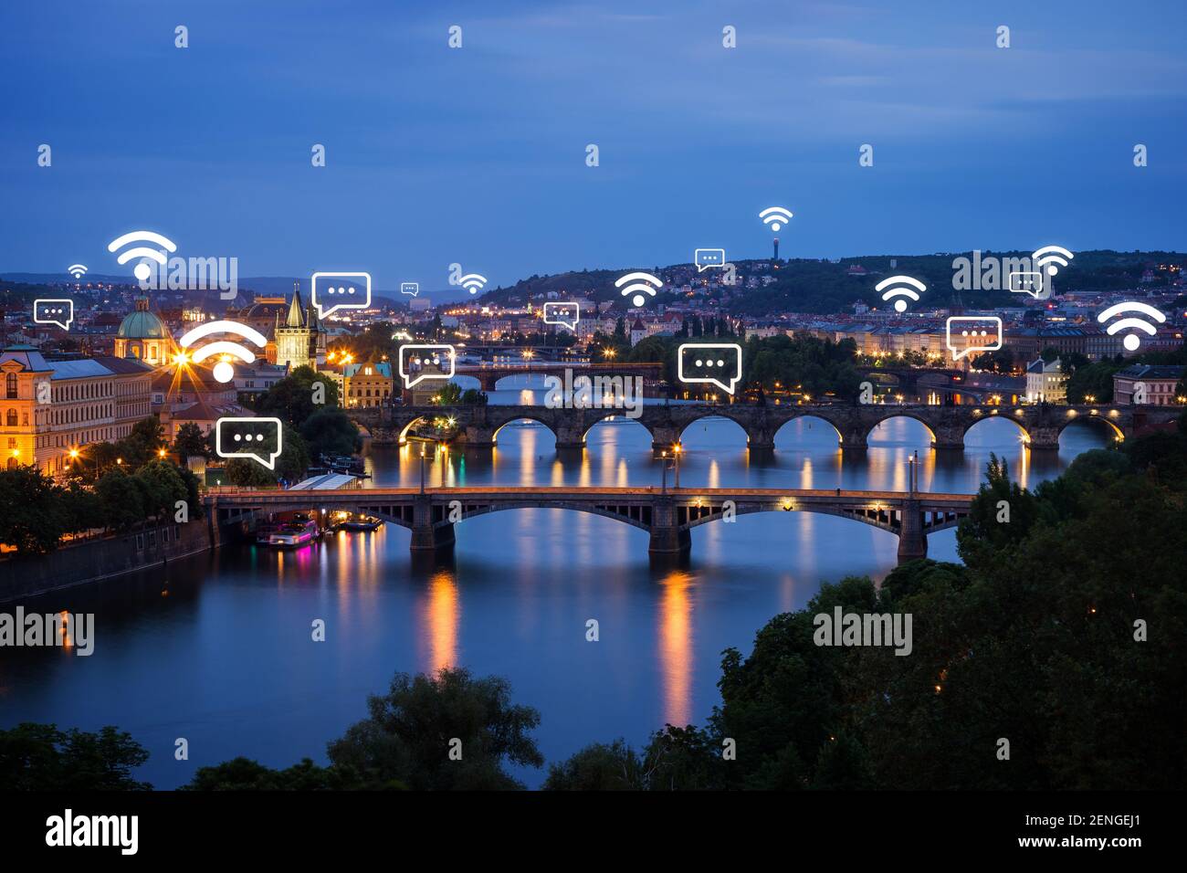 Lit buildings and bridges over Vltava River in Prague, Czech Republic, at dusk. Wireless network connection, WiFi, smart city and online messaging con Stock Photo