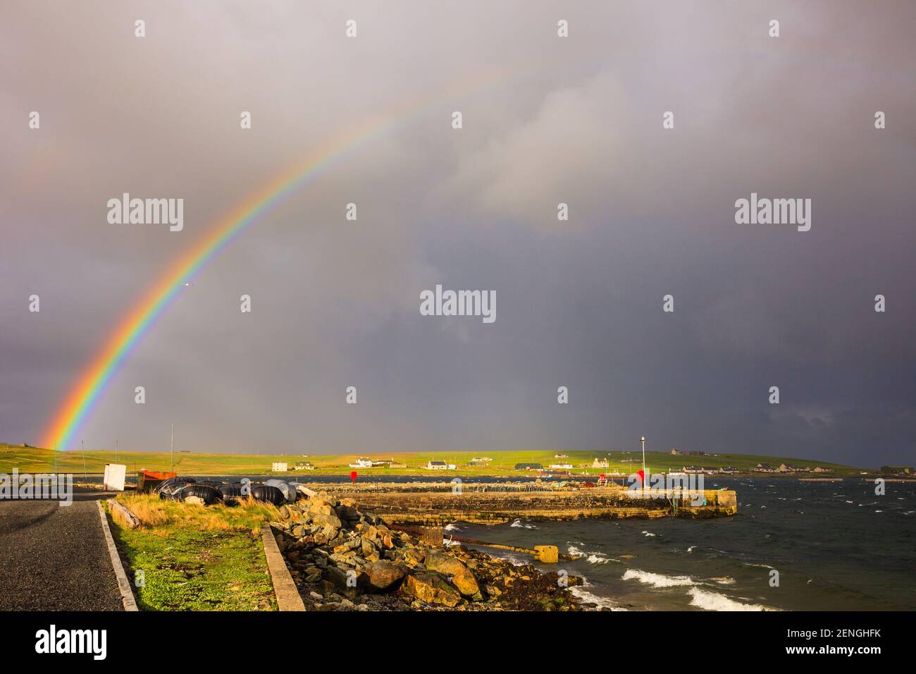 Colourful rainbow and dark clouds over the sea in summer. Uyeasound, Unst, Shetland Islands, Scotland, UK, Britain Stock Photo