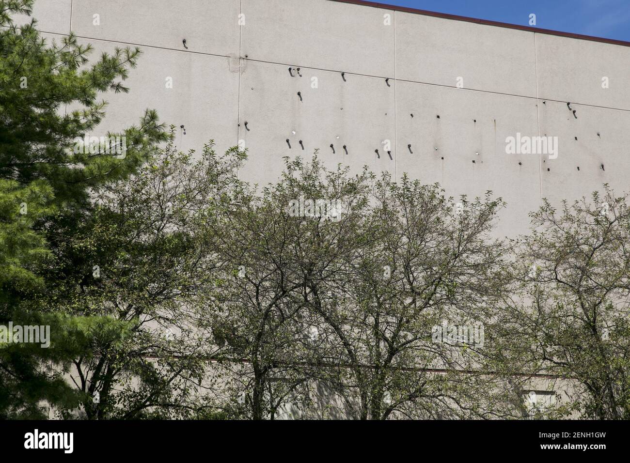 The faded outline of a Dillard's logo sign outside of a closed and abandoned retail store