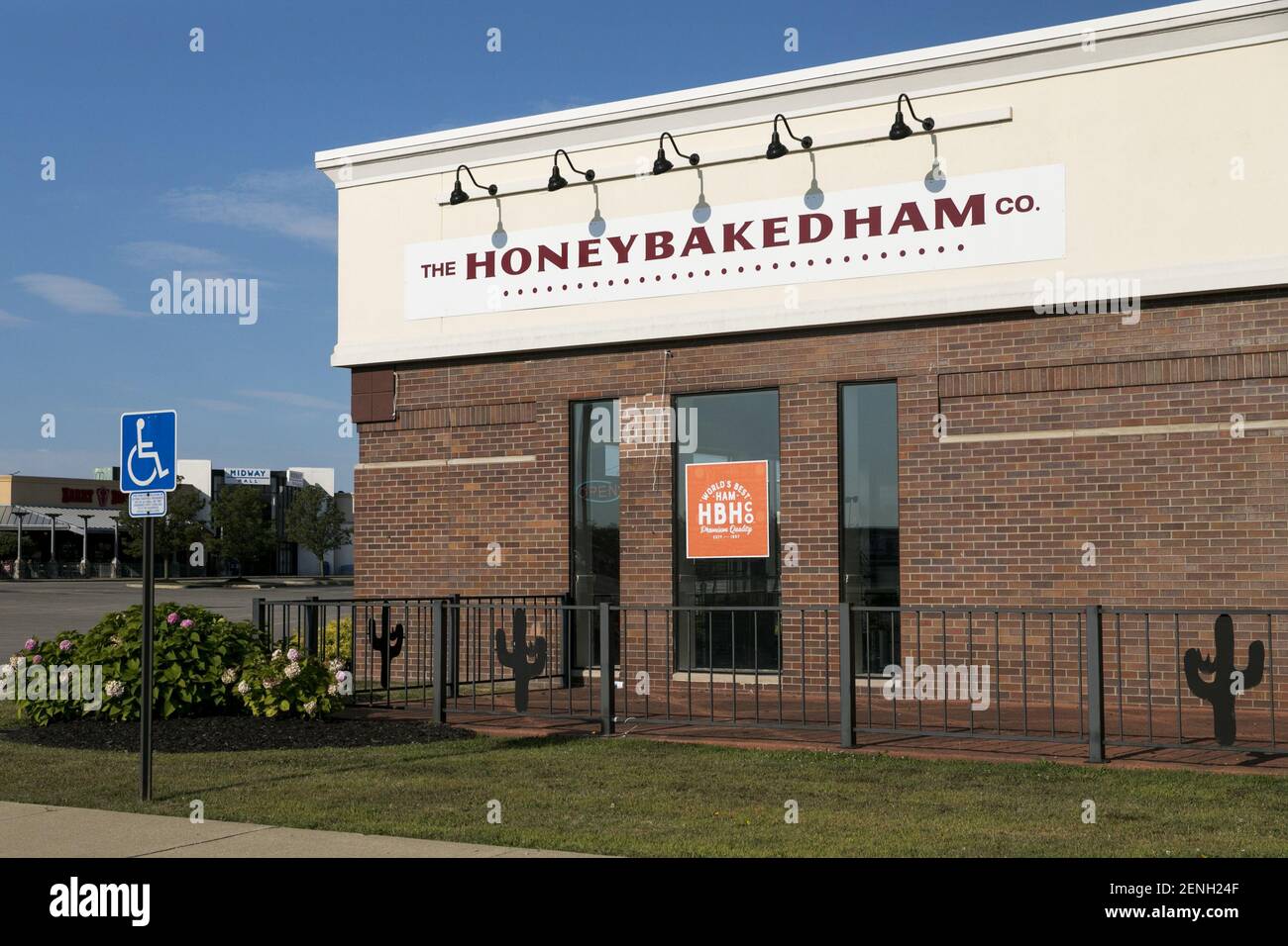 A logo sign outside of a The Honey Baked Ham Company retail store