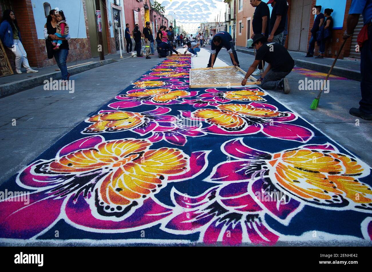 HUAMANTLA , MEXICO AUGUST 14: People are seen elaborating a colored sawdust carpets, an ephemeral art in honor of the Virgin of Charity, on August 14, 2019 in Huamantla, Mexico. Inhabitants of HUAMANTLA , MEXICO AUGUST 14: People are seen elaborating a colored sawdust carpets, an ephemeral art in honor of the Virgin of Charity, on August 14, 2019 in Huamantla, Mexico. Inhabitants of