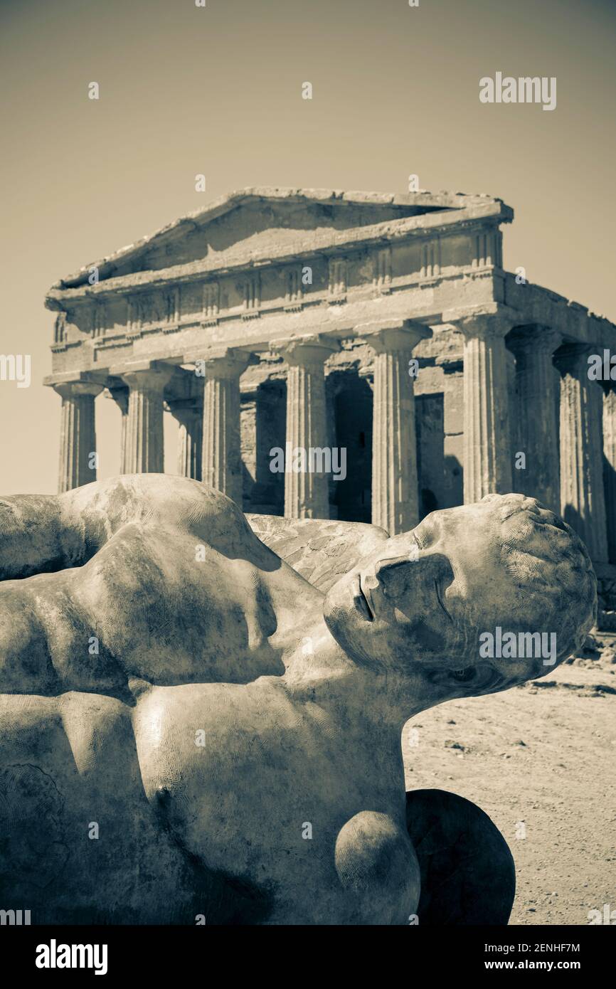 Italy, Sicily, Agrigento, Valley of the Temples, Temple of Concord (5th century BC) with a bronze statue of Fallen Icarus Stock Photo