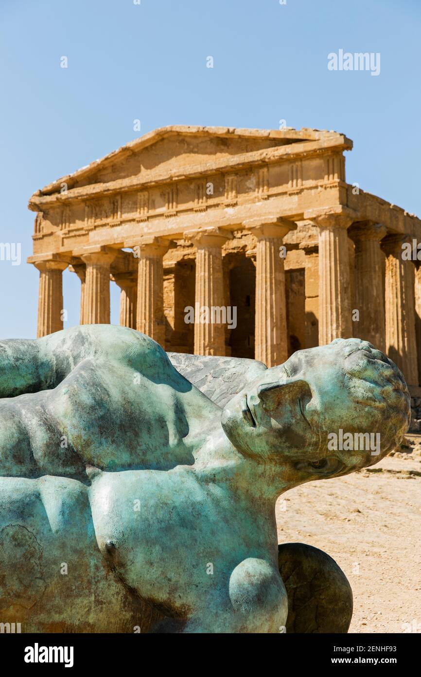 Italy, Sicily, Agrigento, Valley of the Temples, Temple of Concord (5th century BC) with a bronze statue of Fallen Icarus Stock Photo