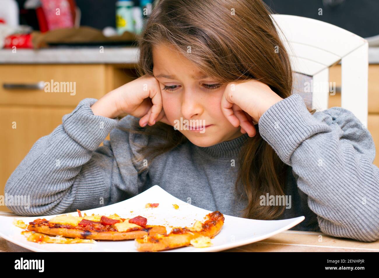Kind vor Teller mit Pizzaresten, MR: Yes Stock Photo