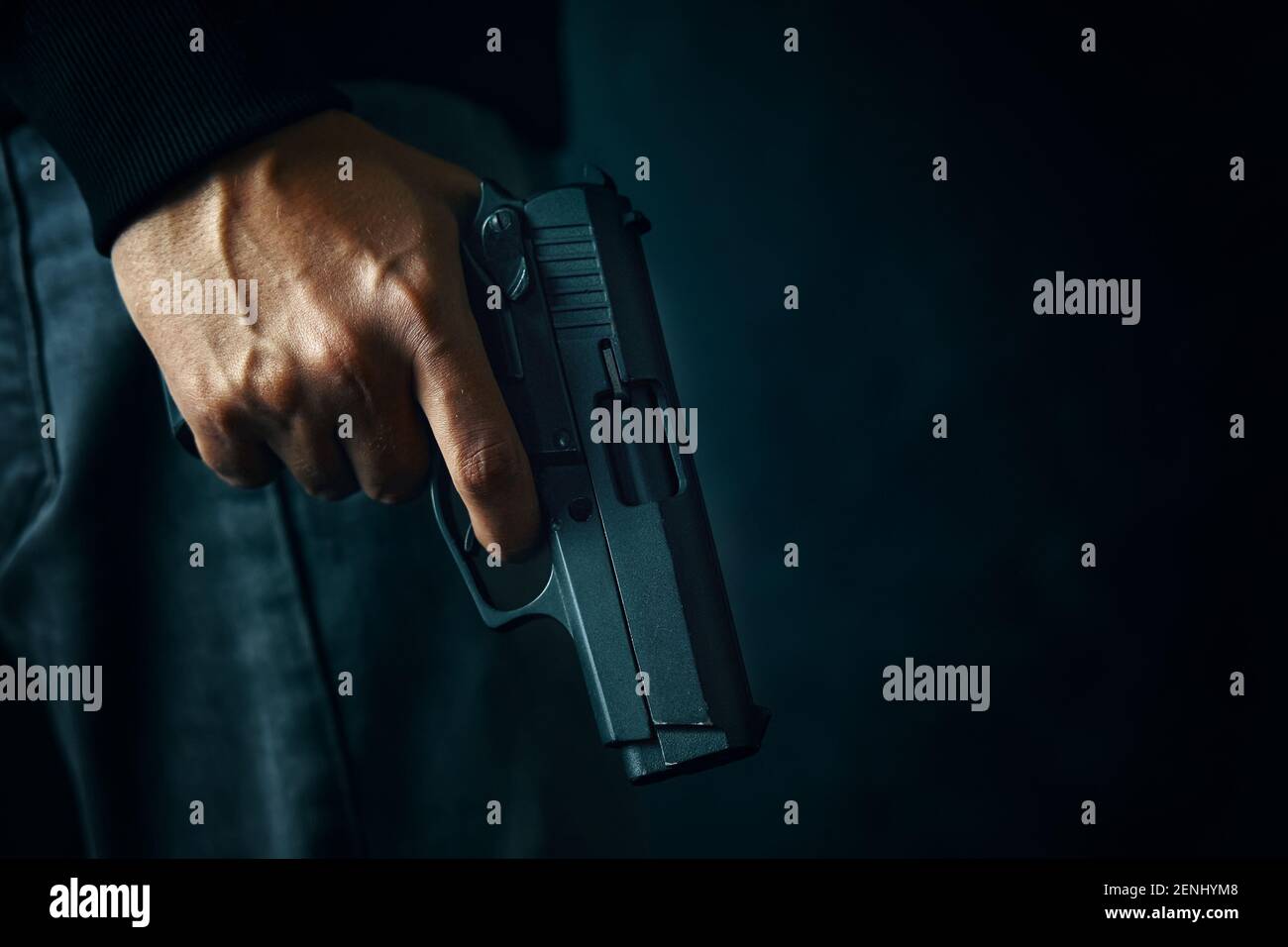 Black revolver with drum in man's hand. Guy with gun down. Firearms for