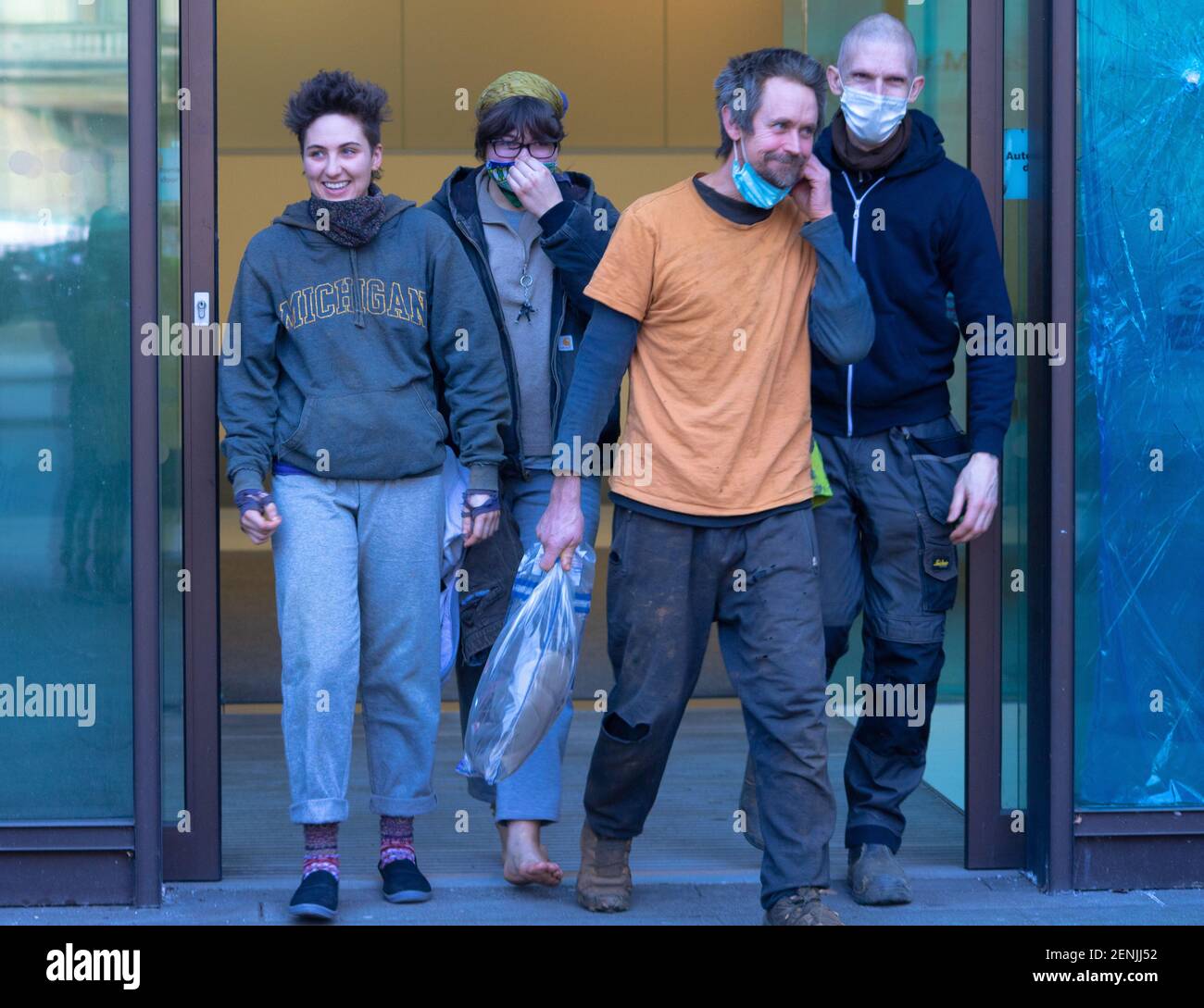 London, UK, 26th February 2021. Anti HS2 protestors and Euston tunnellers Dan Hooper, known as Swampy, Blue and Nemo leave Westminster Magistrates Court. The three protestors were evicted from the tunnel yesterday morning at 7am after spending 30 days underground in protest at the HS2 project and the destruction of Euston Square Gardens to create a temporary taxi rank. They celebrate with bubbly and Dr Larch Maxey comes to greet them. Stock Photo