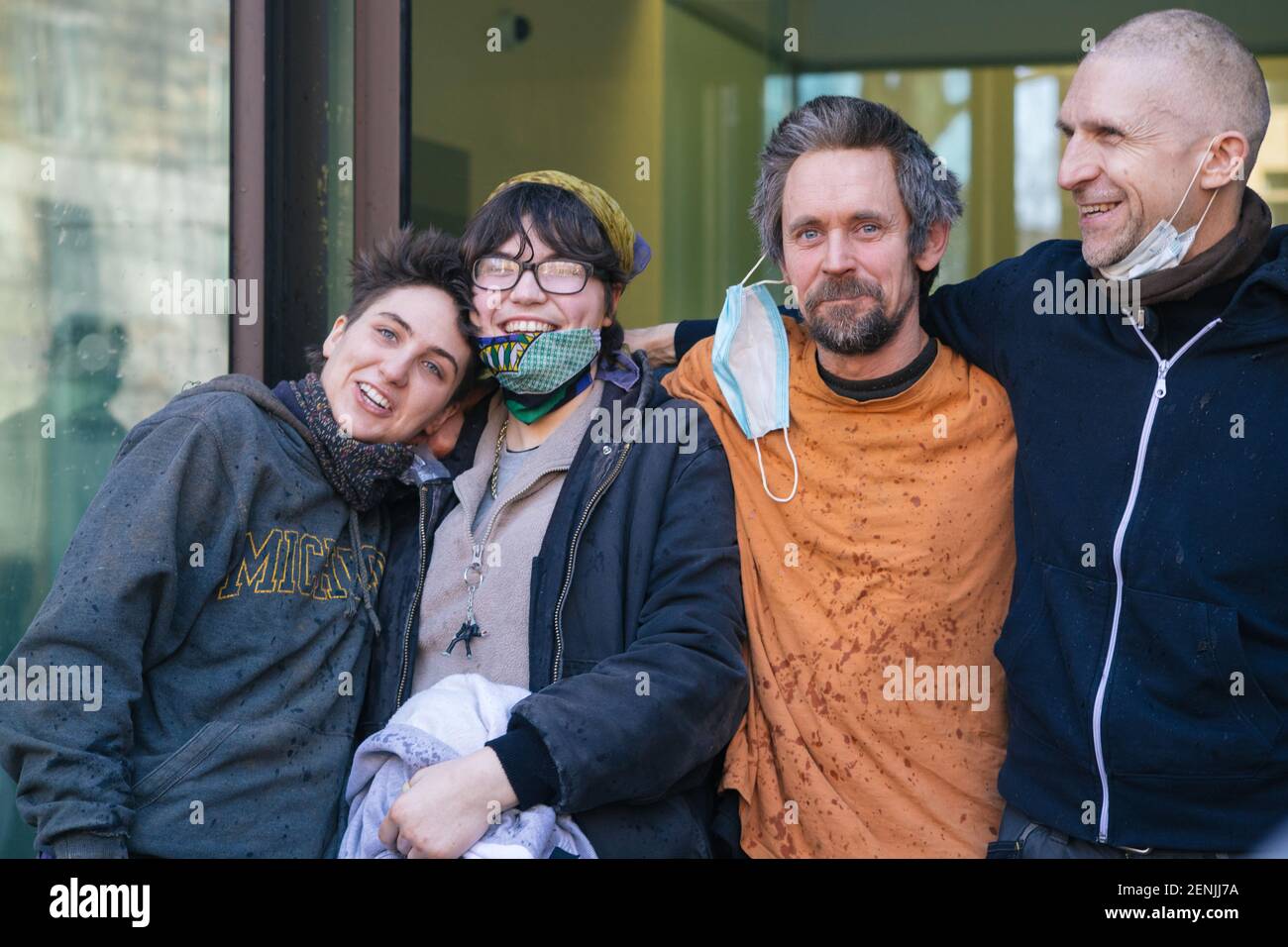 London, UK, 26th February 2021. Anti HS2 protestors and Euston tunnellers Dan Hooper, known as Swampy, Blue and Nemo leave Westminster Magistrates Court. The three protestors were evicted from the tunnel yesterday morning at 7am after spending 30 days underground in protest at the HS2 project and the destruction of Euston Square Gardens to create a temporary taxi rank. They celebrate with bubbly and Dr Larch Maxey comes to greet them. Stock Photo