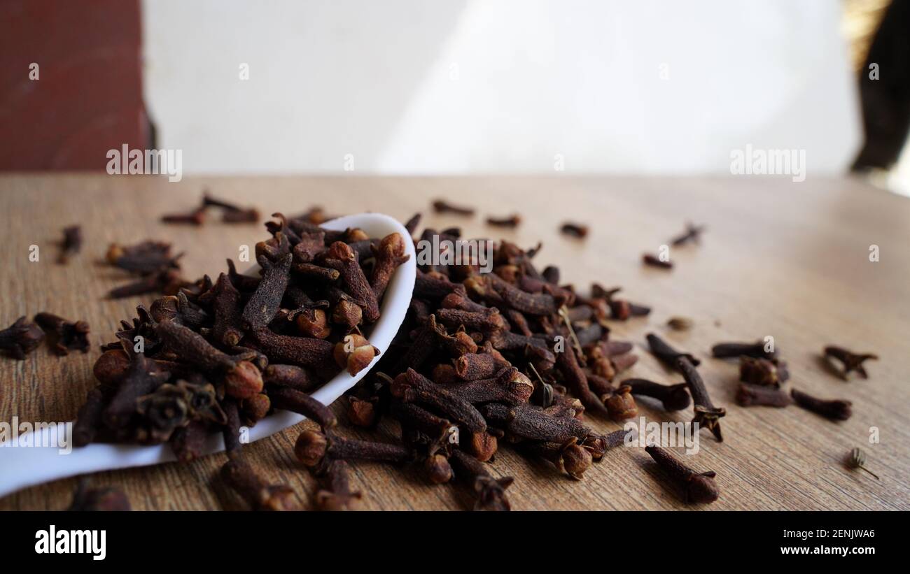 Indian dried clove spice on wooden table background. Dry aromatic