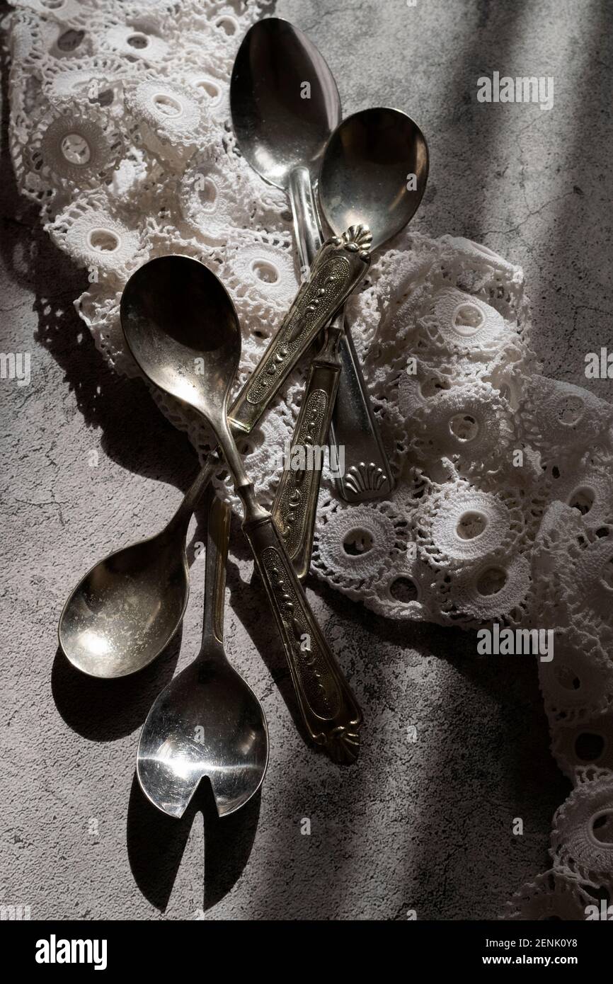Antique silver spoons with handmade embroidery napkin Stock Photo