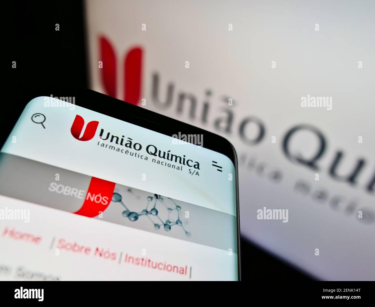 Mobile phone with web page of company União Química Farmacêutica Nacional S.A. on screen in front of logo. Focus on top-center of cellphone display. Stock Photo