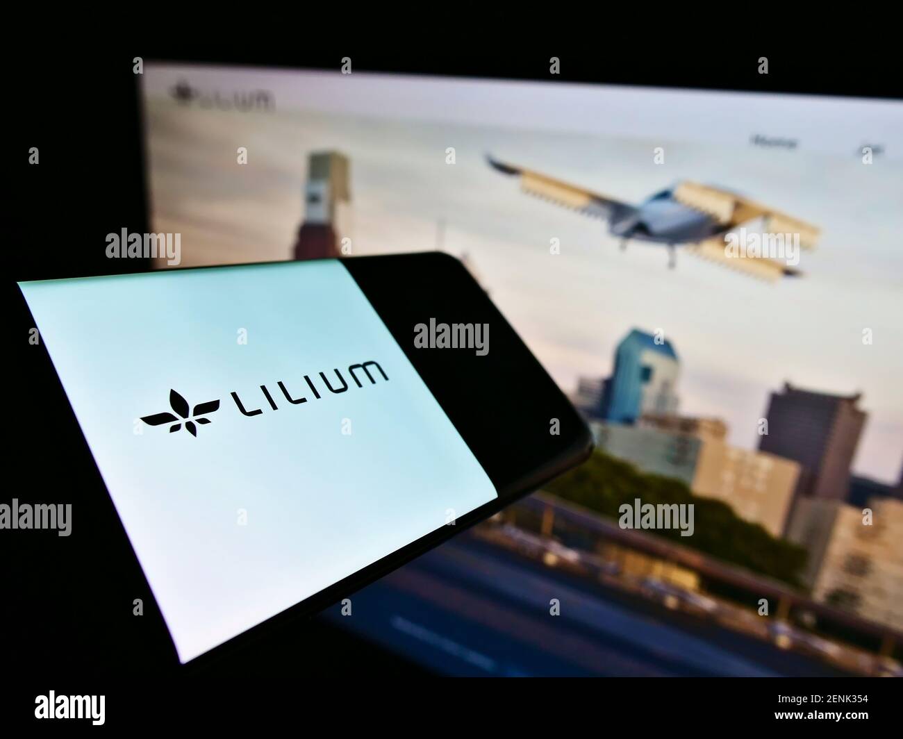 Cellphone with company logo of German airplane manufacturer Lilium GmbH (Lilium Jet) on screen in front of website. Focus on center of phone display. Stock Photo