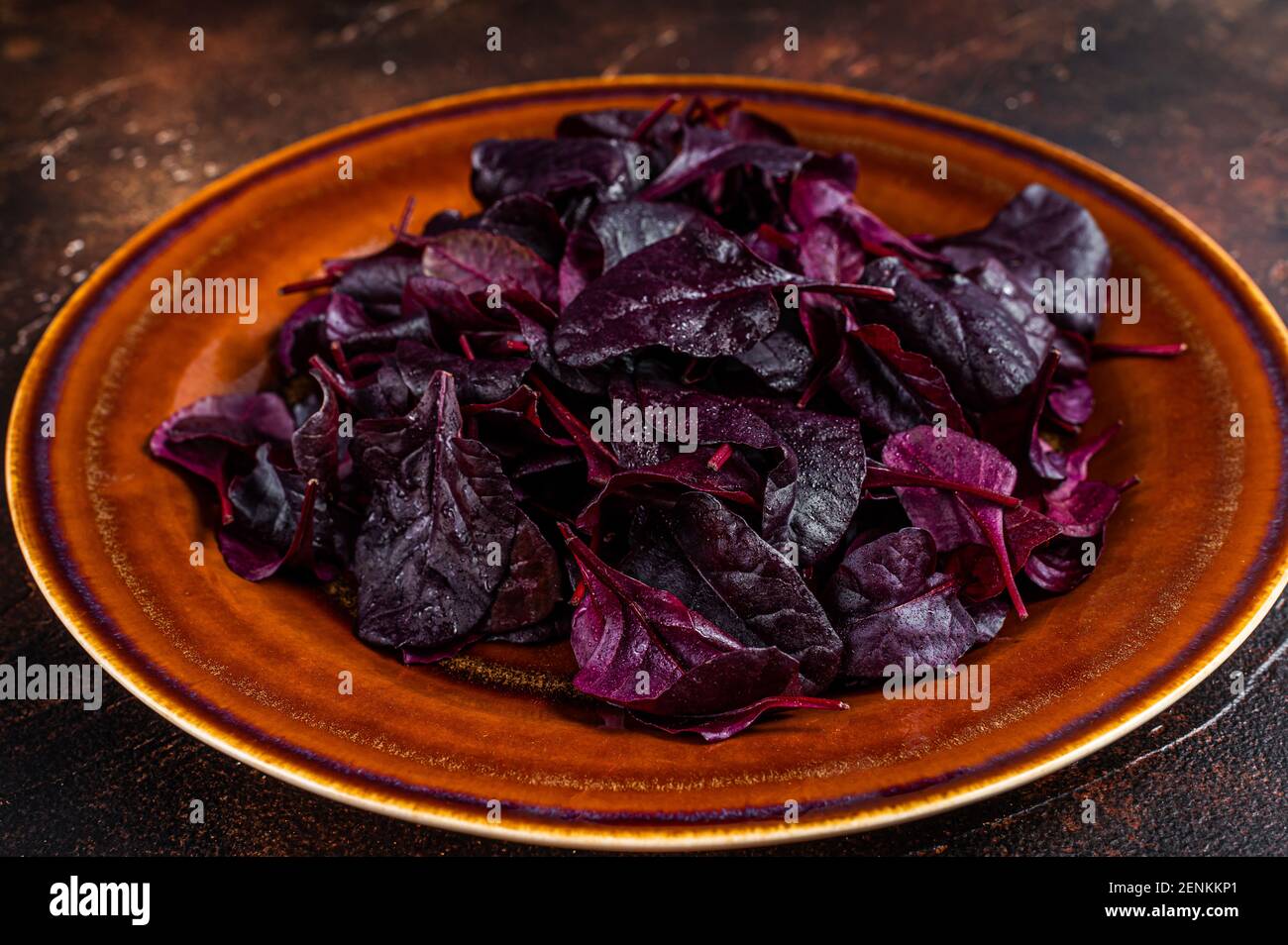 Raw Ruby or red chard salad Leafs on a rustic plate. Dark background. Top view Stock Photo