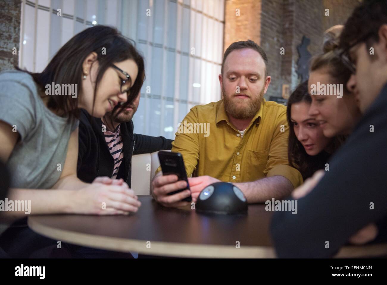 Students looking at smart phone together Stock Photo