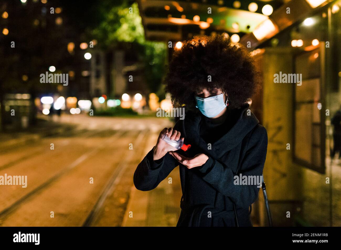 Woman using hand sanitizer, wearing face mask Stock Photo - Alamy