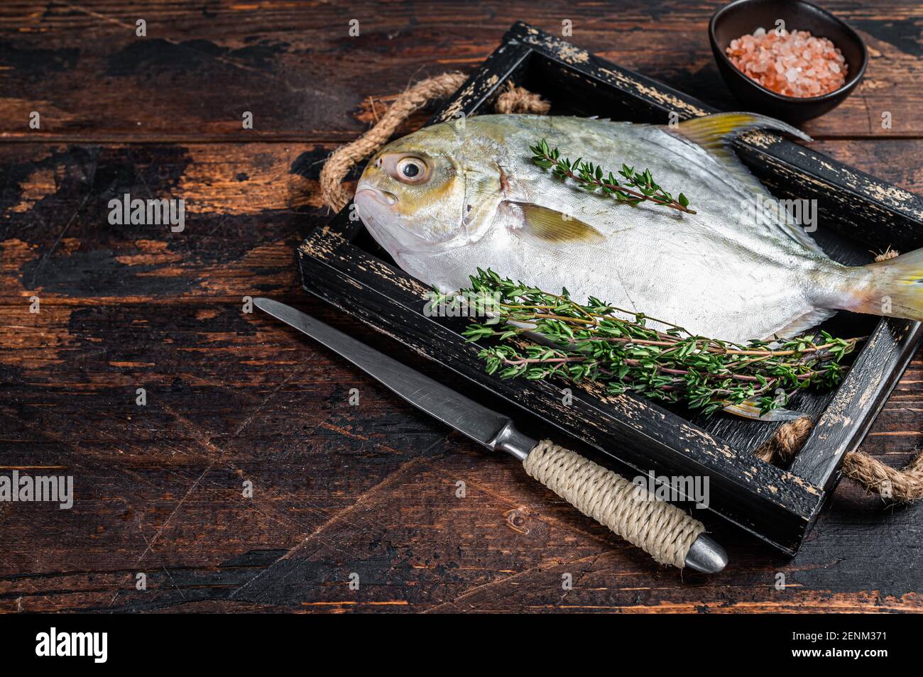 Raw fish butterfish or pompano with herbs in a wooden tray. Dark wooden  background. Top view. Copy space Stock Photo - Alamy
