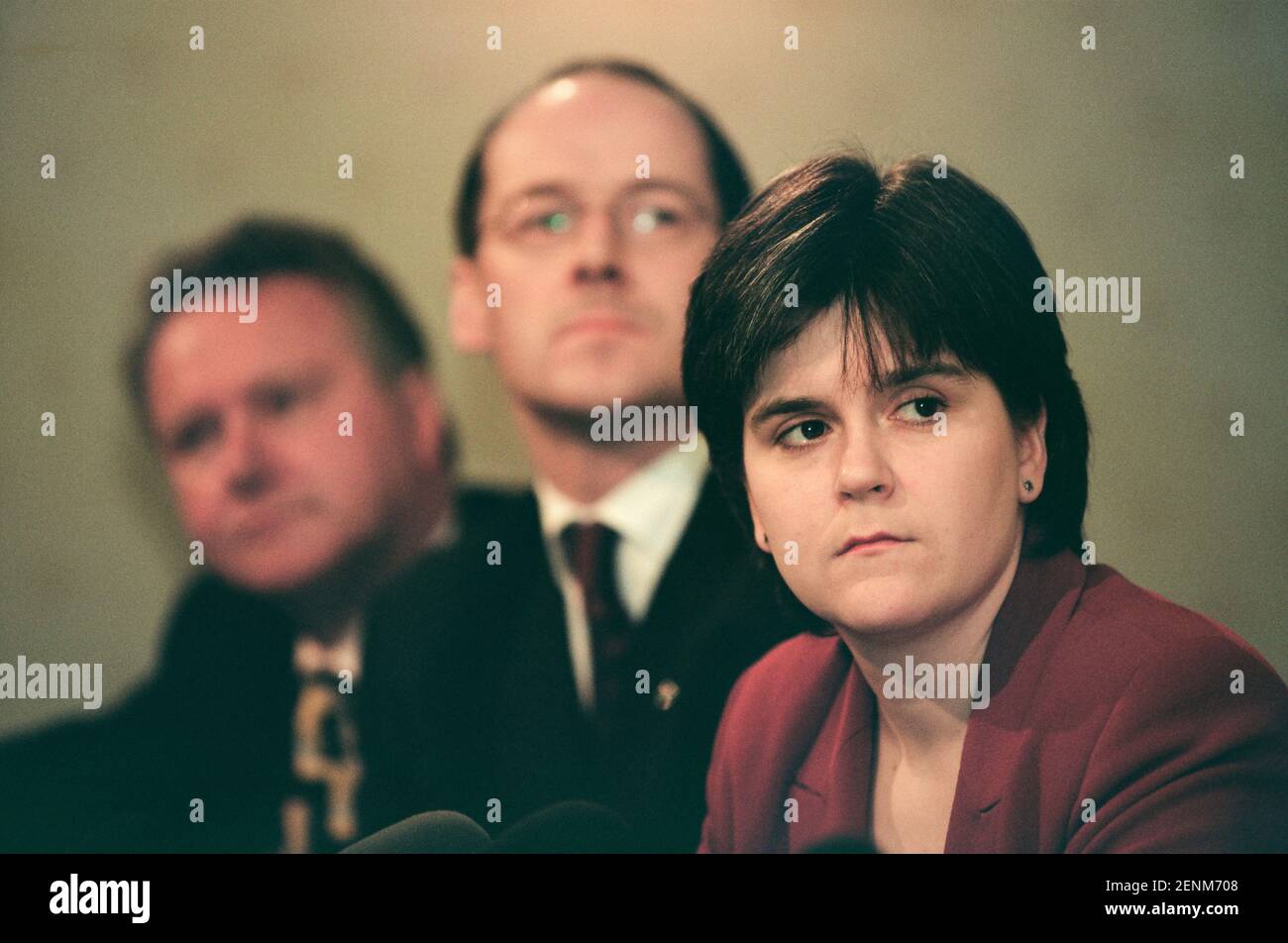 The Scottish National Party's Nicola Sturgeon (right) listening to her party leader Alex Salmond addressing the media at the launch of the SNP's 1999 manifesto for the Holyrood election campaign in Edinburgh, Scotland. Ms Sturgeon was elected to the newly-created Scottish parliament in 1999 and went on to serve as the country's Deputy First Minister under Alex Salmond MSP and then as First Minister. At the time of the 1999 election she was working as a solicitor in the Drumchapel Law and Money Advice Centre in Glasgow. Stock Photo