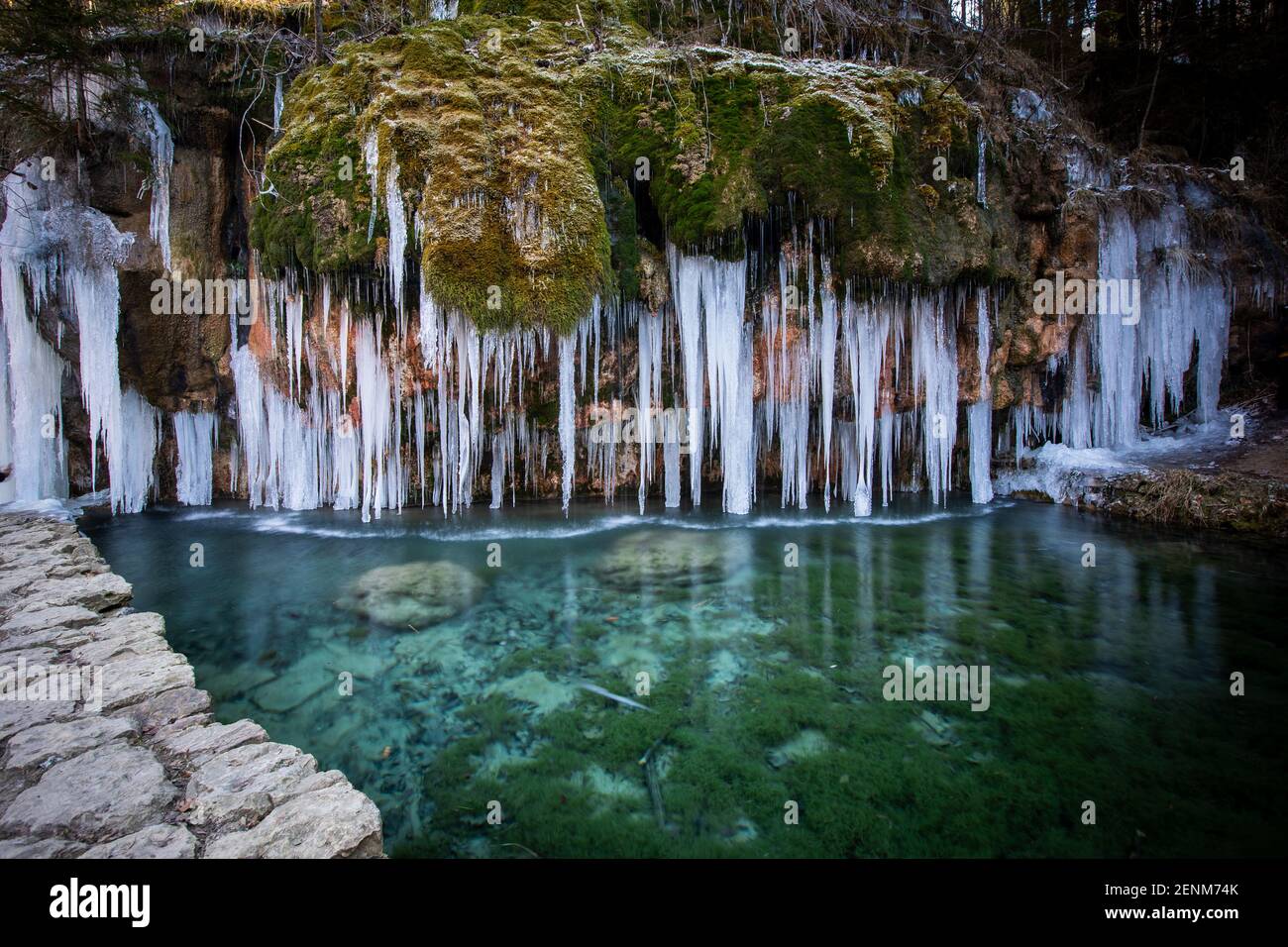 At the Travertine source situated in the valley of the Ernz Noire crystal-clear calcareous water flows over a rock formation into a basin. Stock Photo