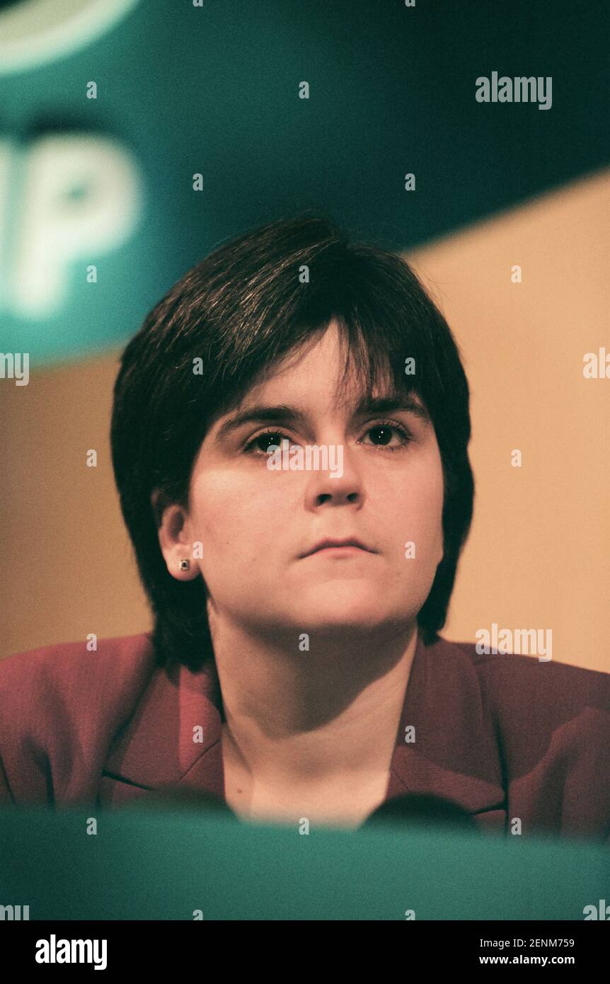 The Scottish National Party's Nicola Sturgeon listening to her party leader Alex Salmond addressing the media at the launch of the SNP's 1999 manifesto for the Holyrood election campaign in Edinburgh, Scotland. Ms Sturgeon was elected to the newly-created Scottish parliament in 1999 and went on to serve as the country's Deputy First Minister under Alex Salmond MSP and then as First Minister. At the time of the 1999 election she was working as a solicitor in the Drumchapel Law and Money Advice Centre in Glasgow. Stock Photo