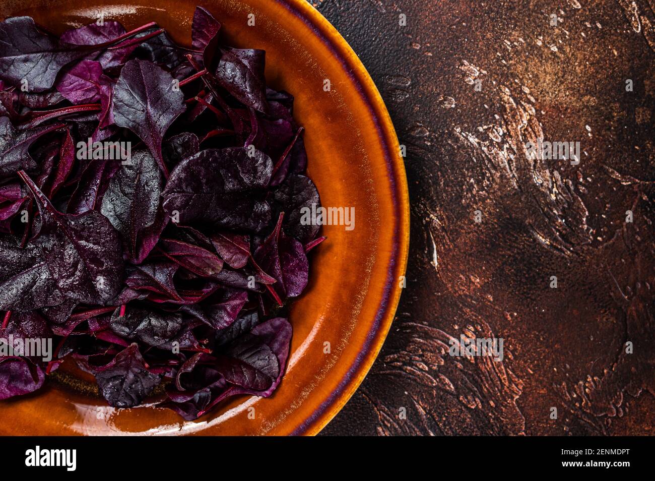 Raw Ruby or red chard salad Leafs on a rustic plate. Dark background. Top view. Copy space Stock Photo