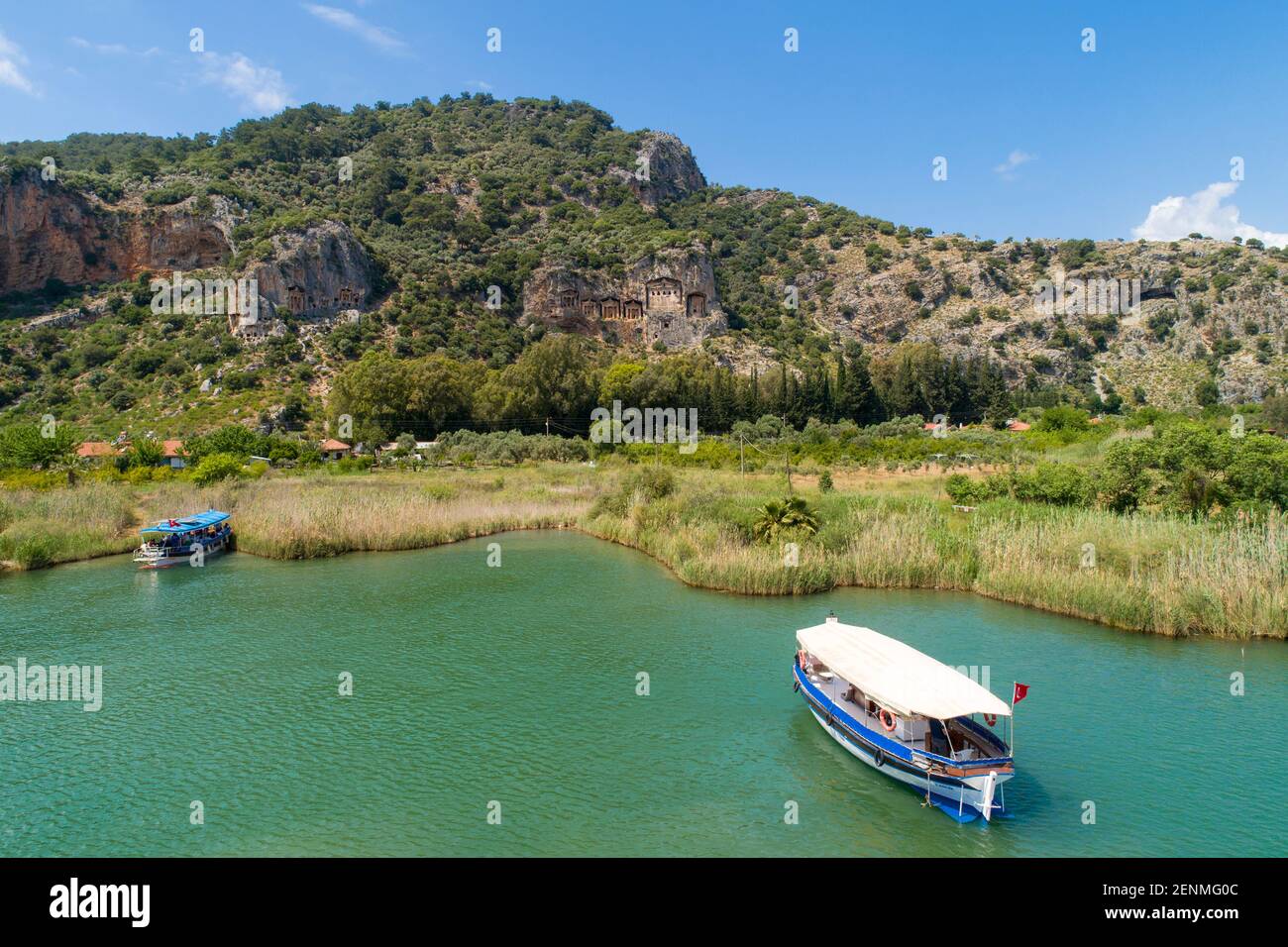Aerial view of boats on Dalyan River with ancient Lycian rock tombs (Tombs of the Kings) in the background, Dalyan, Province of Muğla, Turkey Stock Photo