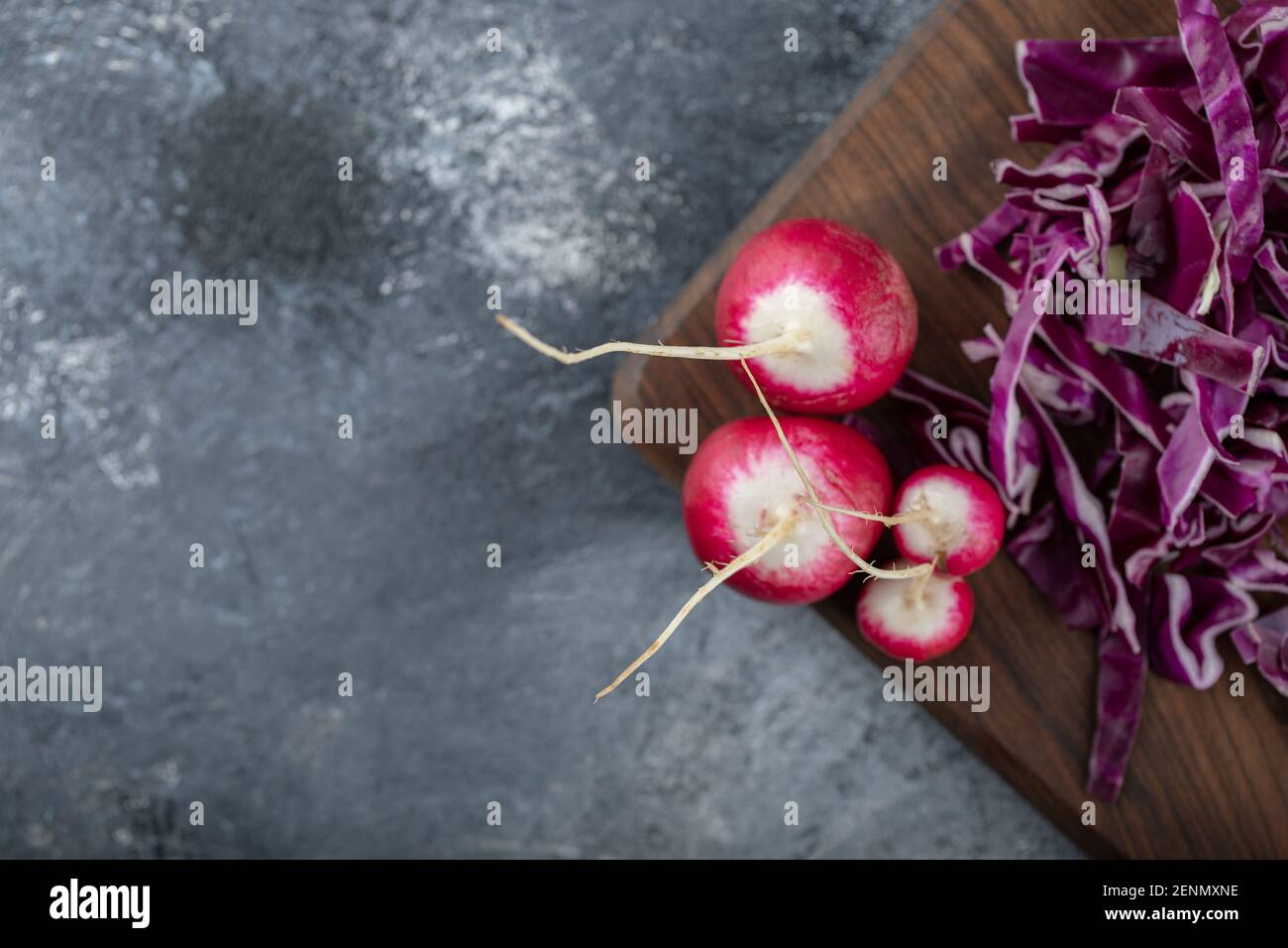 Chopped cabbage and radish on wooden board over grey background Stock Photo