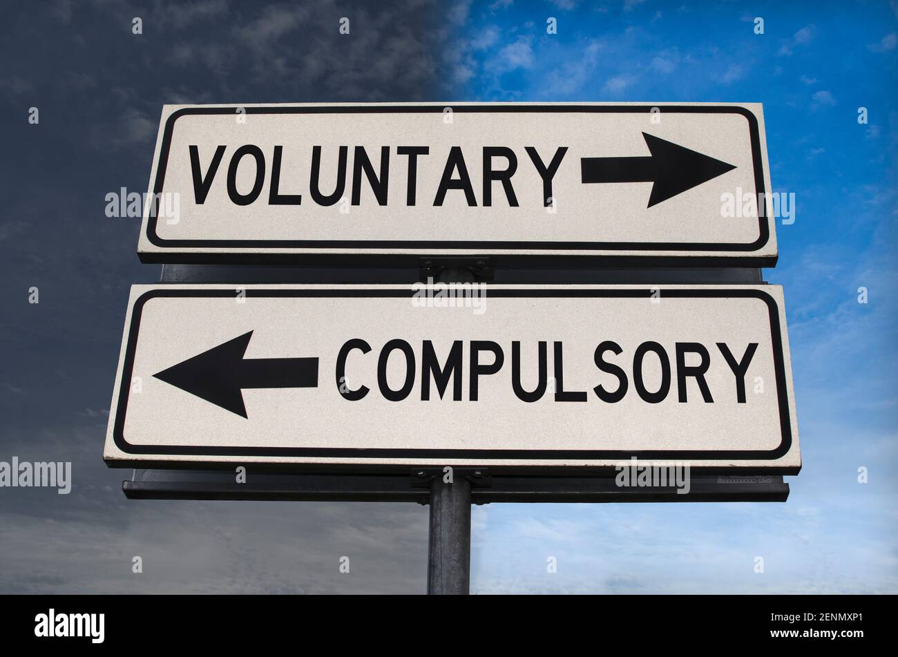 Voluntary versus compulsory road sign with two arrows on blue and grey sky background. White two street sign with arrows on metal pole. Two way road s Stock Photo