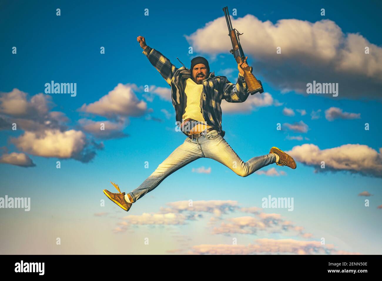 Excited hunter man jumping with shotgun gun on hunt. Crazy hunter on sky  background Stock Photo - Alamy