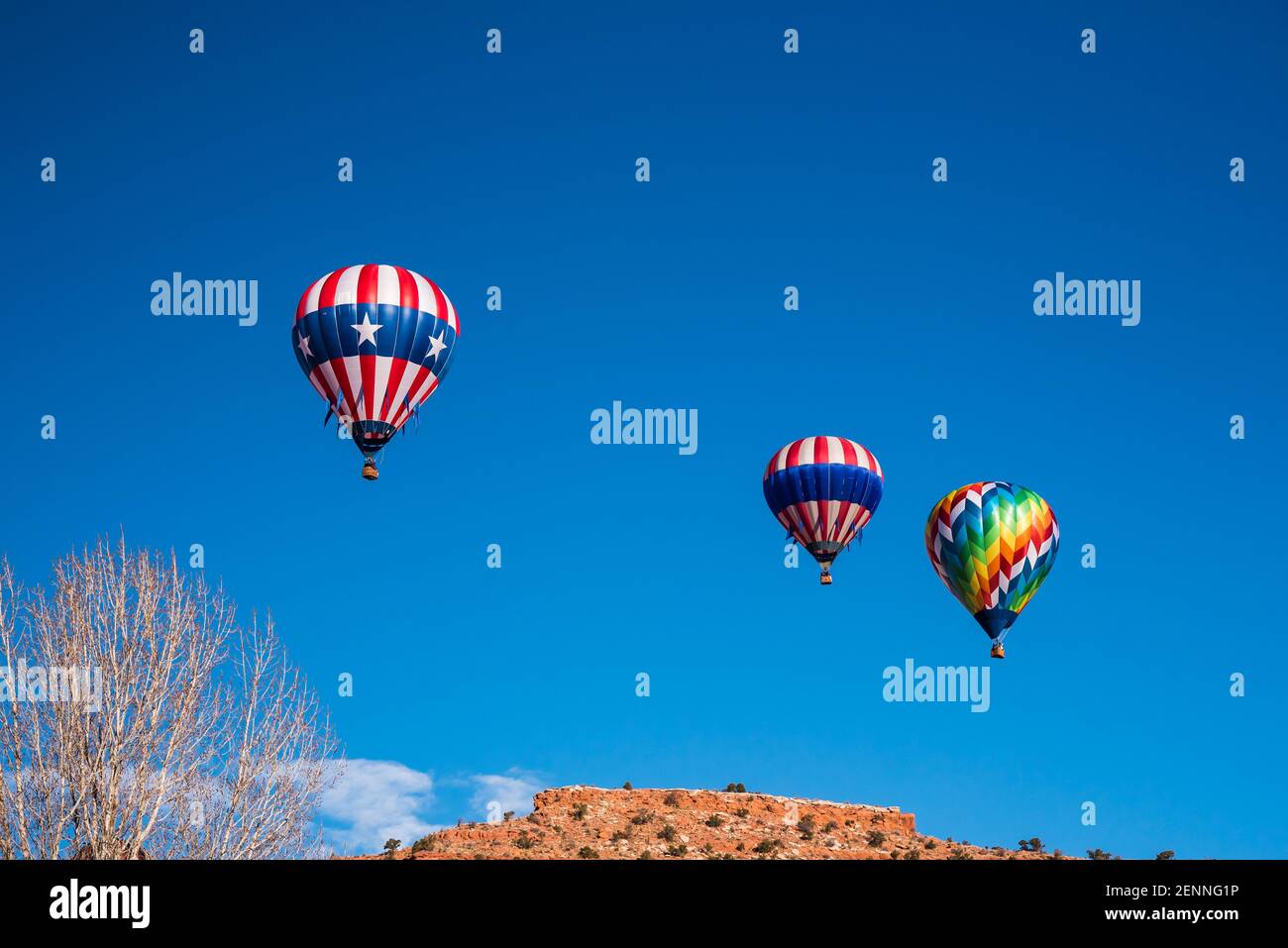 Hot air balloons in the cobalt blue skies above the red rock cliffs of Kanab, Utah, USA.  This small town is famous for its western atmosphere. Stock Photo