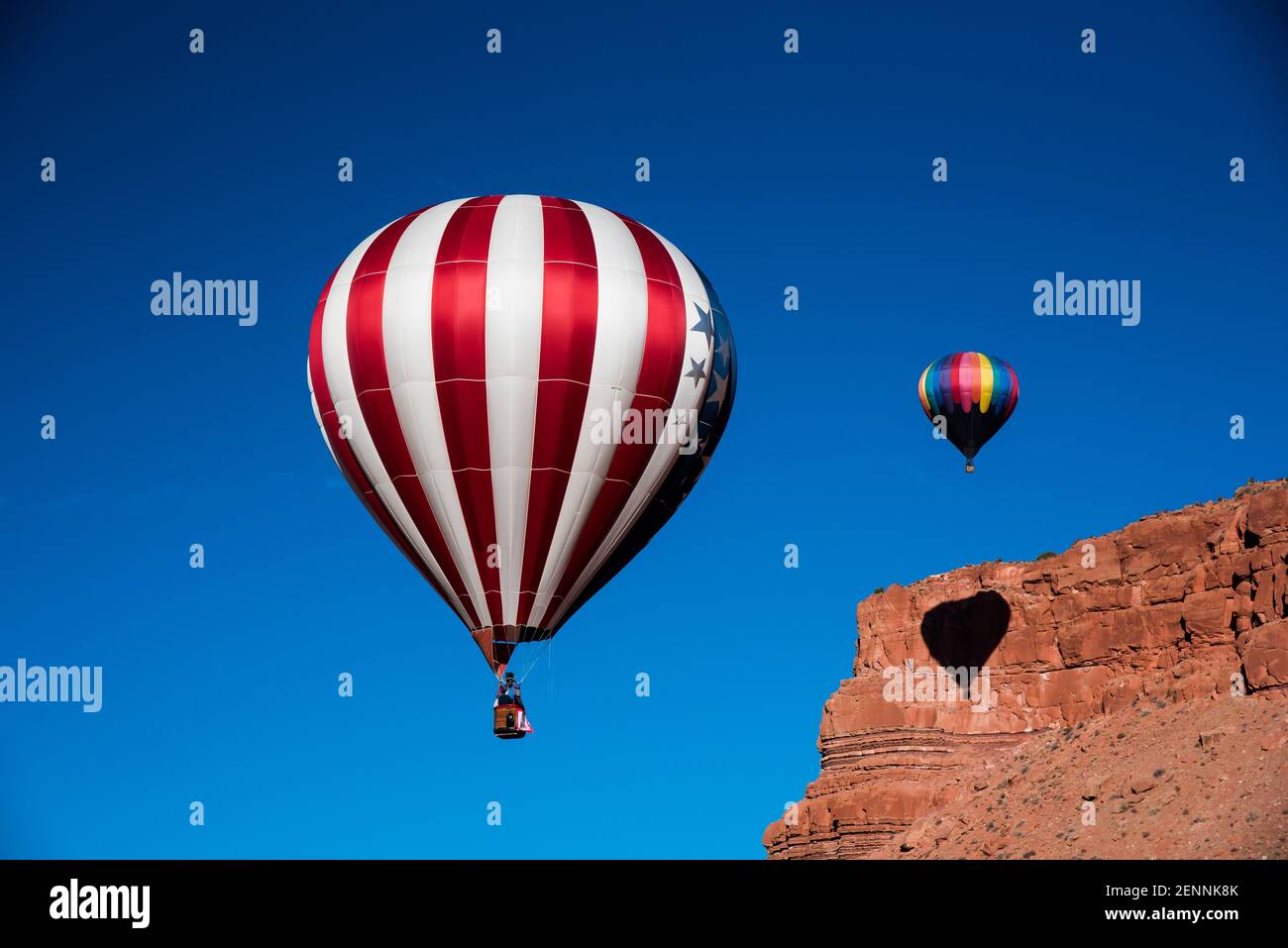 Hot air balloons in the cobalt blue skies above the red rock cliffs of Kanab, Utah, USA.  This small town is famous for its western atmosphere. Stock Photo
