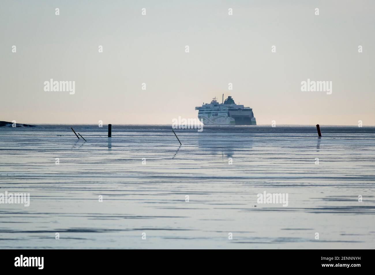 Helsinki / Finland - FEBRUARY 26, 2021: A view of a frozen sea with a large passenger RORO-ferry in the background. Stock Photo