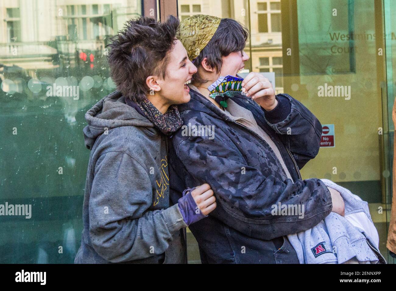 London, UK. 26th Feb 2021. Blue (18) and Nemo (20) laugh as  Swampy (Daniel Hooper, 48) sprays champagne on them as they leave Westminster Magistrates Court.  The tree of them left the tunnels under Euston Square on Thursday 25th February, 2021. A little bath of glory and affection organised by fellow activists and friends is awaiting them. Stock Photo