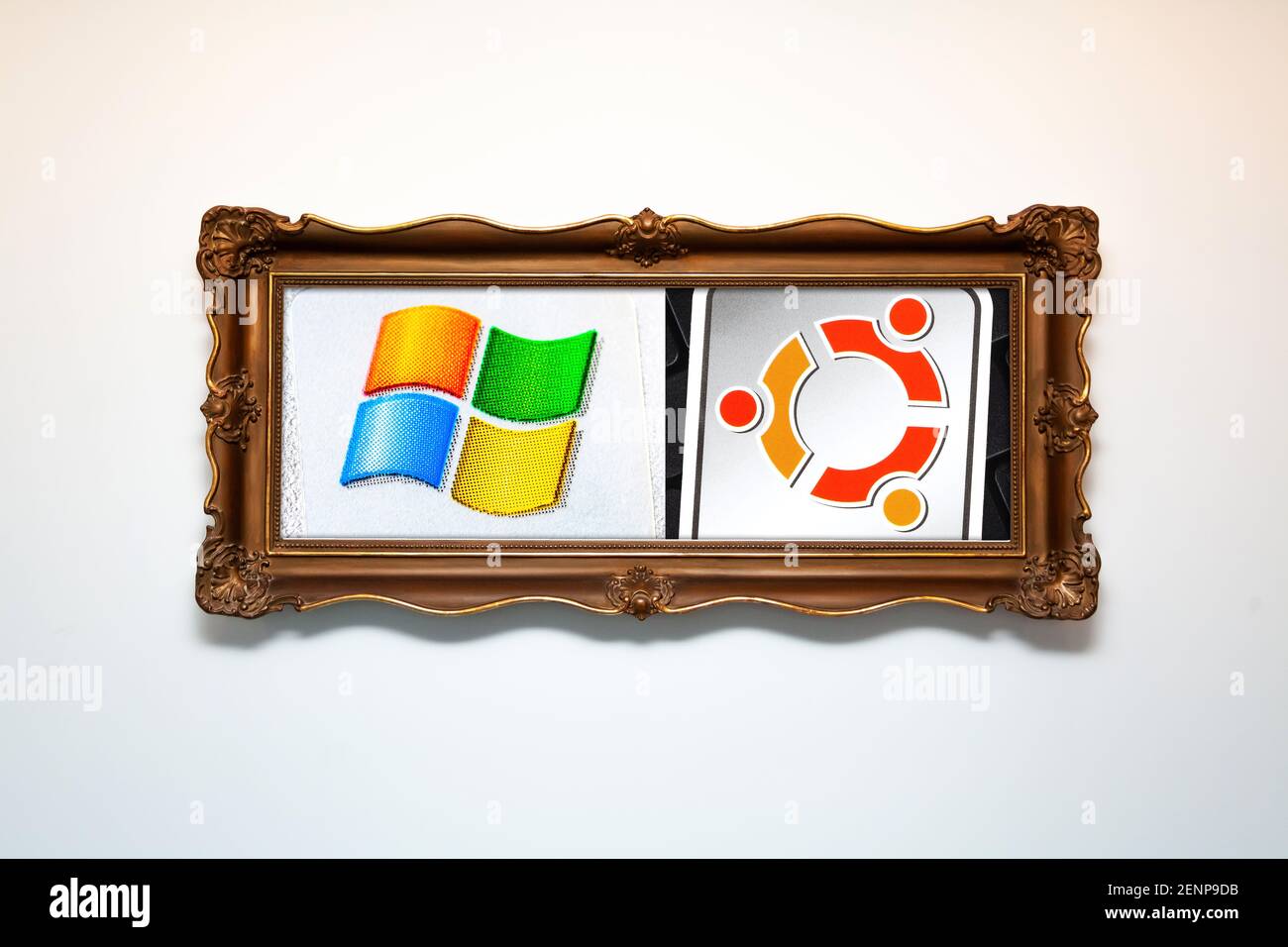 Windows vs Ubuntu abstract concept. Operating system logos in an old painting frame. OS choice, decisions, alternatives, dual boot conceptual, nobody Stock Photo