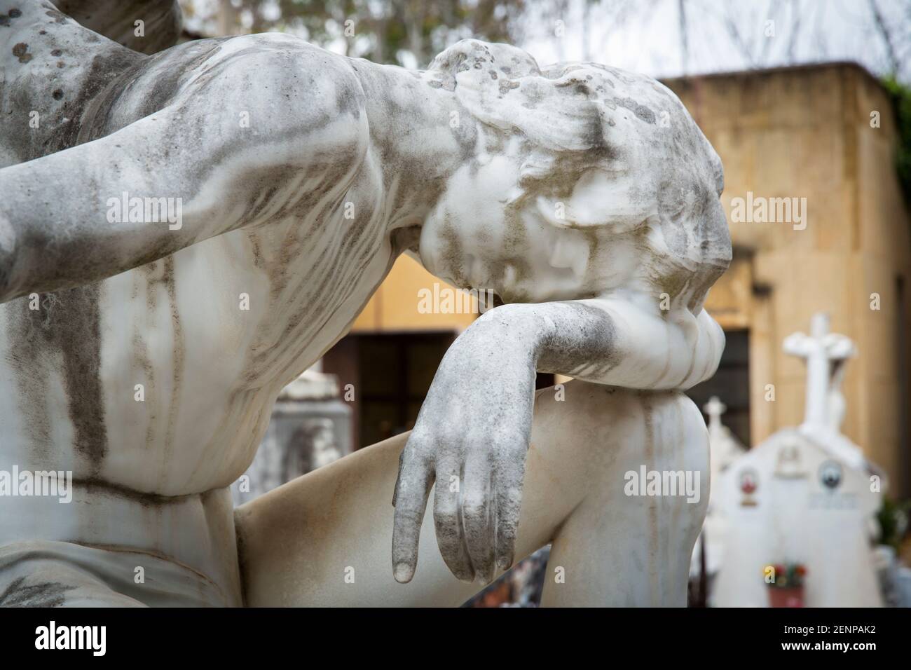 Statue of angel grieving at a gravesite Stock Photo