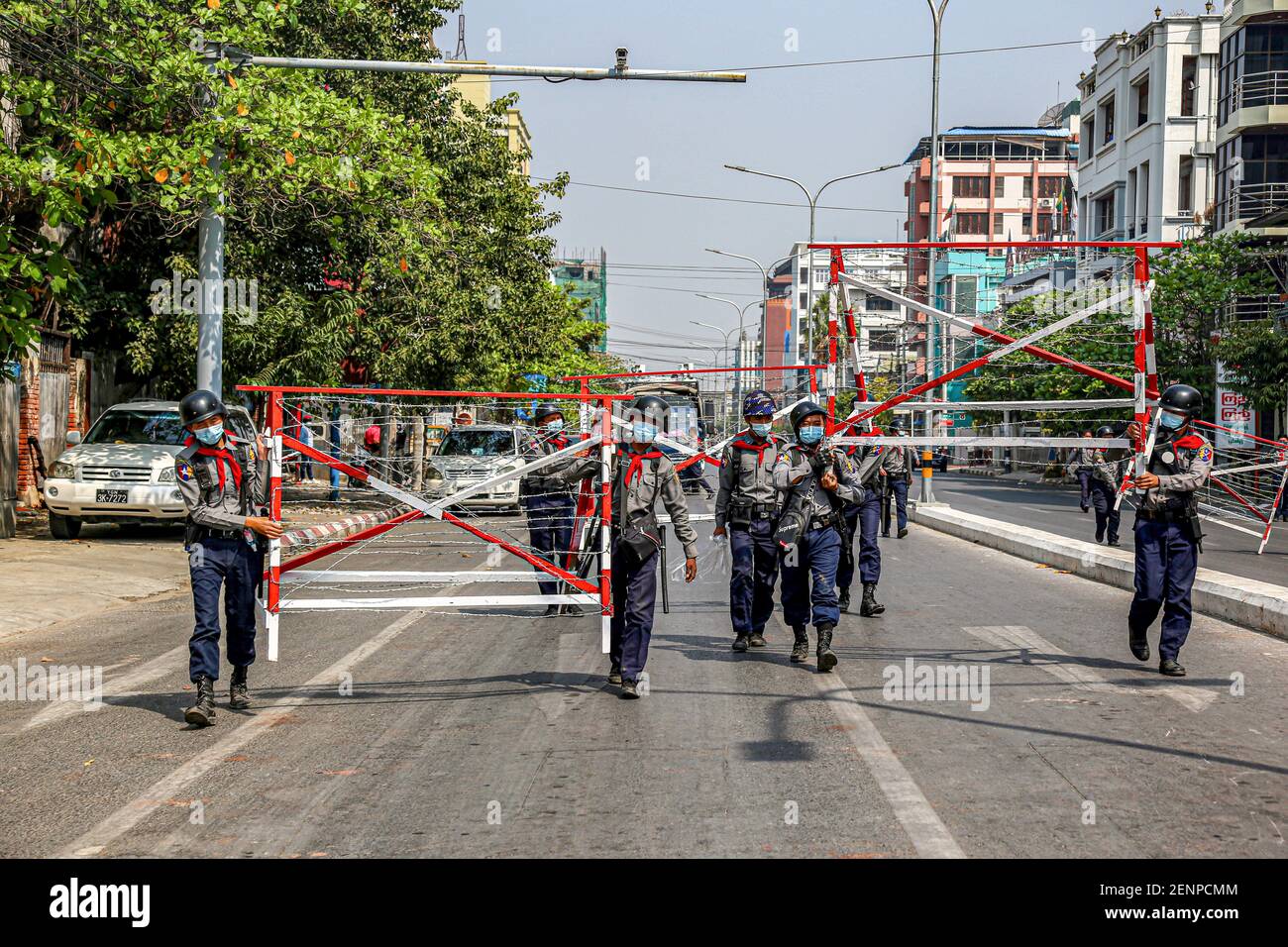 Mandalay, Myanmar. 26th Feb, 2021. Police carry barricade to block the street during an anti-coup demonstration.Myanmar Security Forces shot at anti-military coup protesters and those close to them with slingshots, rubber bullets and other materials thus injuring young children and many were arrested. Credit: SOPA Images Limited/Alamy Live News Stock Photo