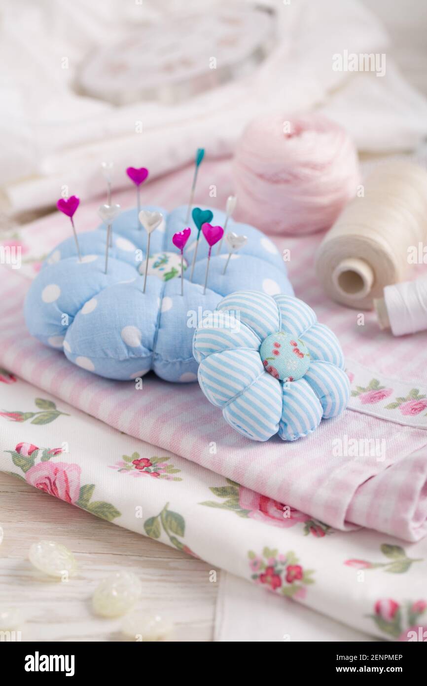 Sewing tools and supplies  - handmade pincushion, scissors, bobbins with thread, needles and fabric. Hobby, crafting, creativity, free time at home co Stock Photo