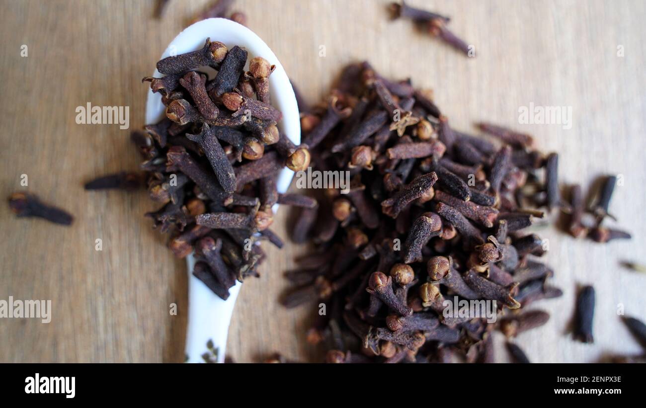 Indian dried clove spice on wooden table background. Dry aromatic