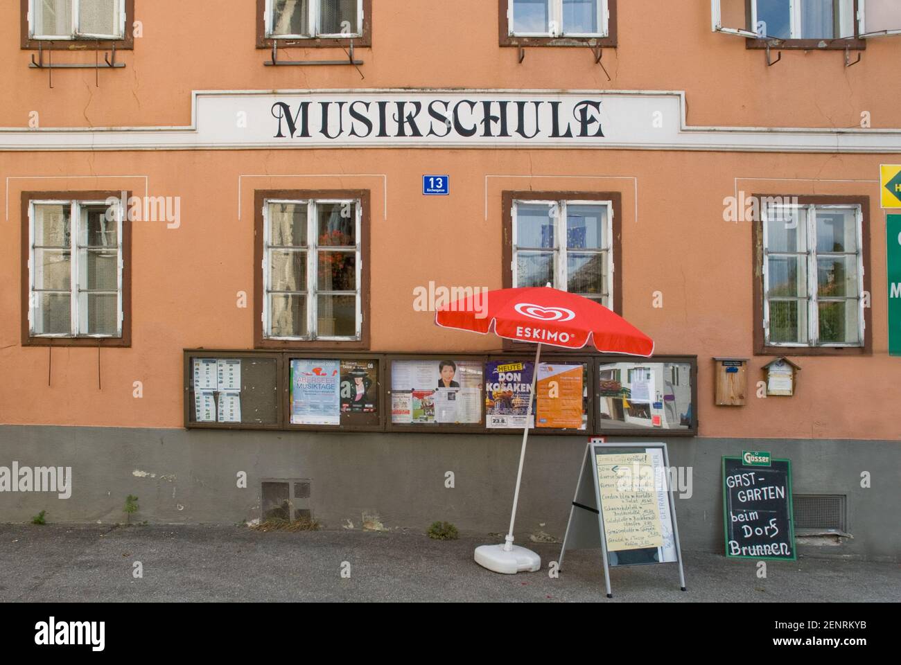 the music scholl in Bad Goisern with posters and red umbrella in front, Bad Goisern, Inner Salzkammergut, Austria Stock Photo