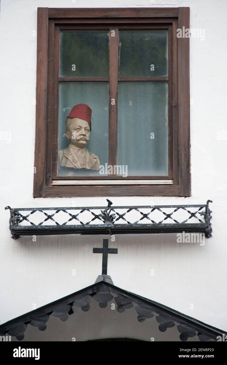 bust with Fez in a window above a christian sculptute in the streets of Hallstatt village, Austria Stock Photo