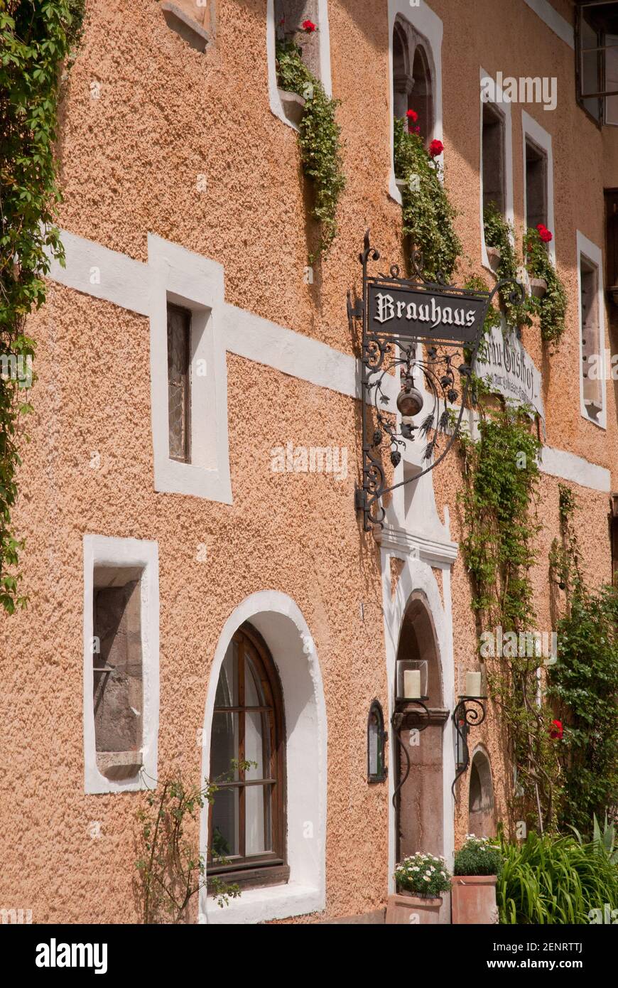 Detail of historic Brauhaus inn facade with windows and flowers in Hallstatt village, Inneres Salzkammergut, Austria Stock Photo
