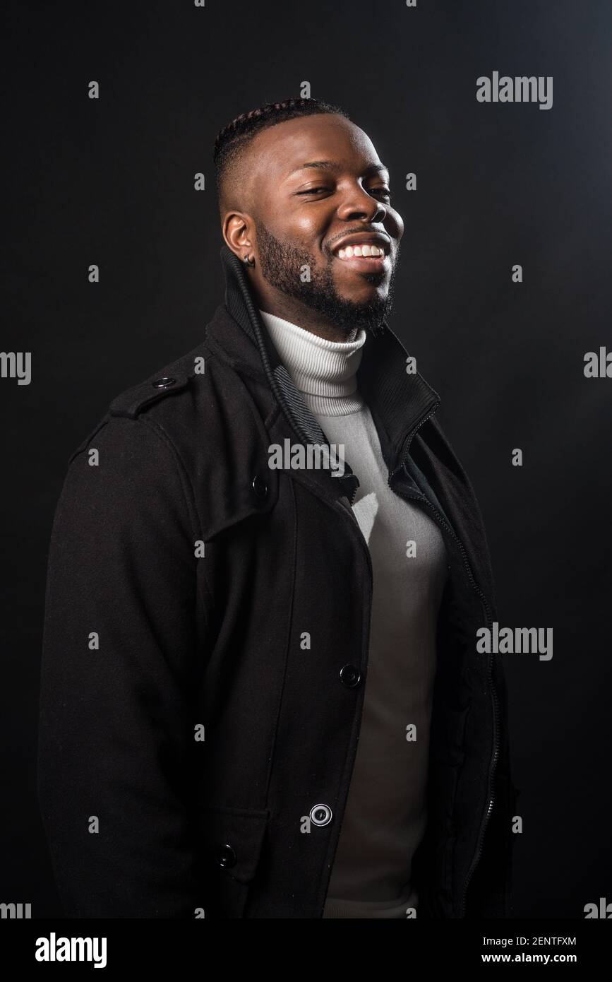 Handsome black man smiling. Mid shot. Black background Stock Photo