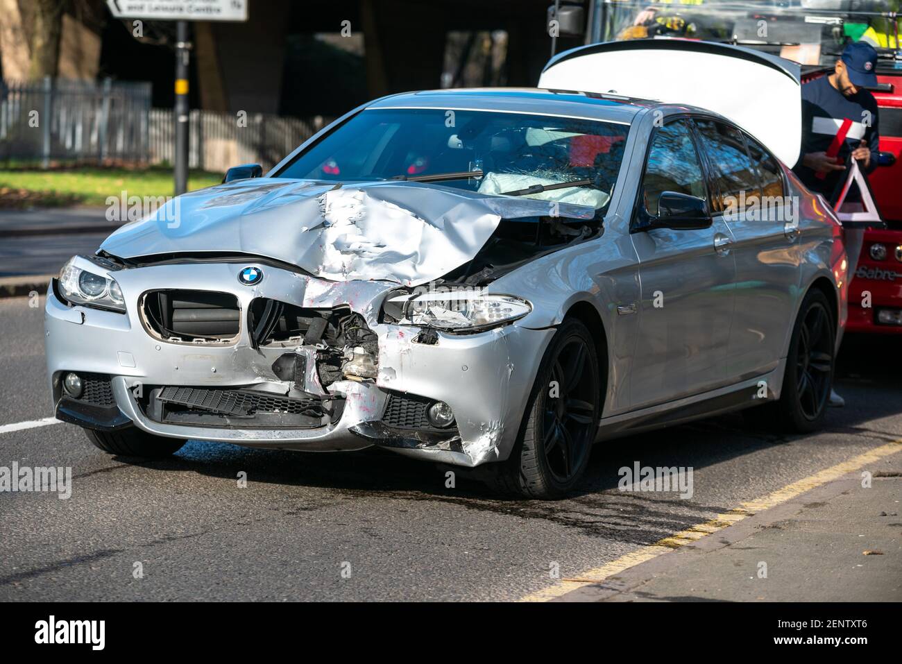 Birmingham, United Kingdom. 26th February 2021. A silver BMW sits with its bonnet and window smashed up after going into the back of a parked double-decker bus on College Road, Perry Barr, Birmingham. Credit: Ryan Underwood / Alamy Live News Stock Photo
