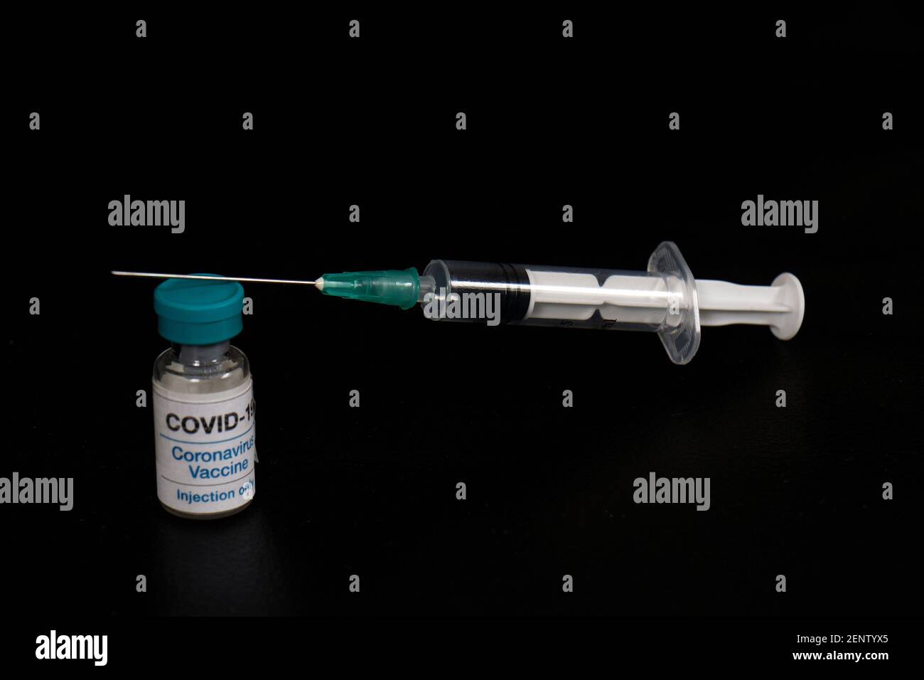 Covid-19 vaccine vial and syringe with needle on black background Stock ...