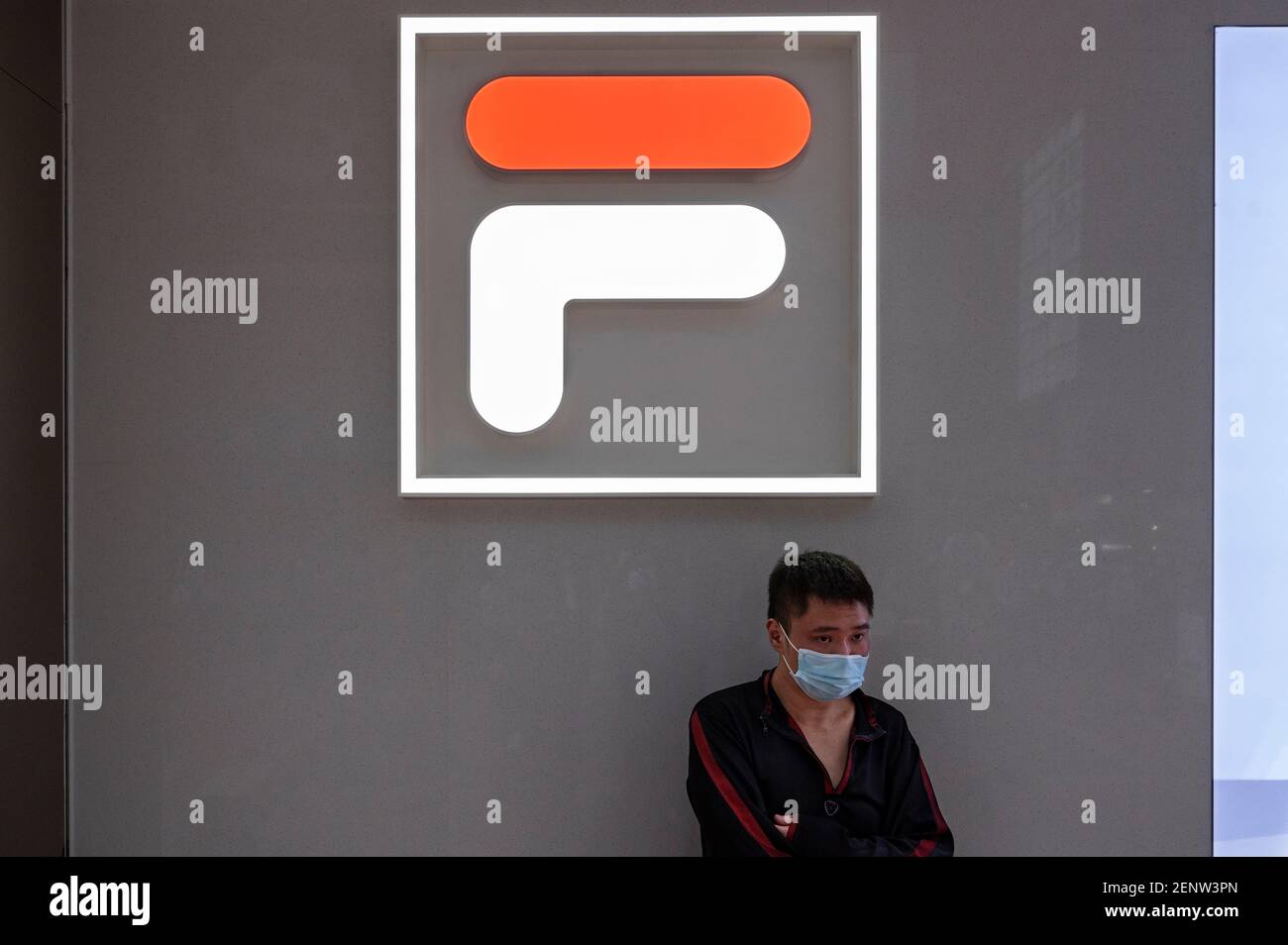 A man wearing a face mask stands outside the Italian sportswear goods  brand, Fila store in Hong Kong. (Photo by Chukrut Budrul / SOPA Images/Sipa  USA Stock Photo - Alamy