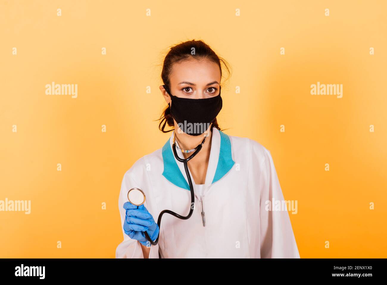 Young smiling African American doctor in medical mask holding syringe ...