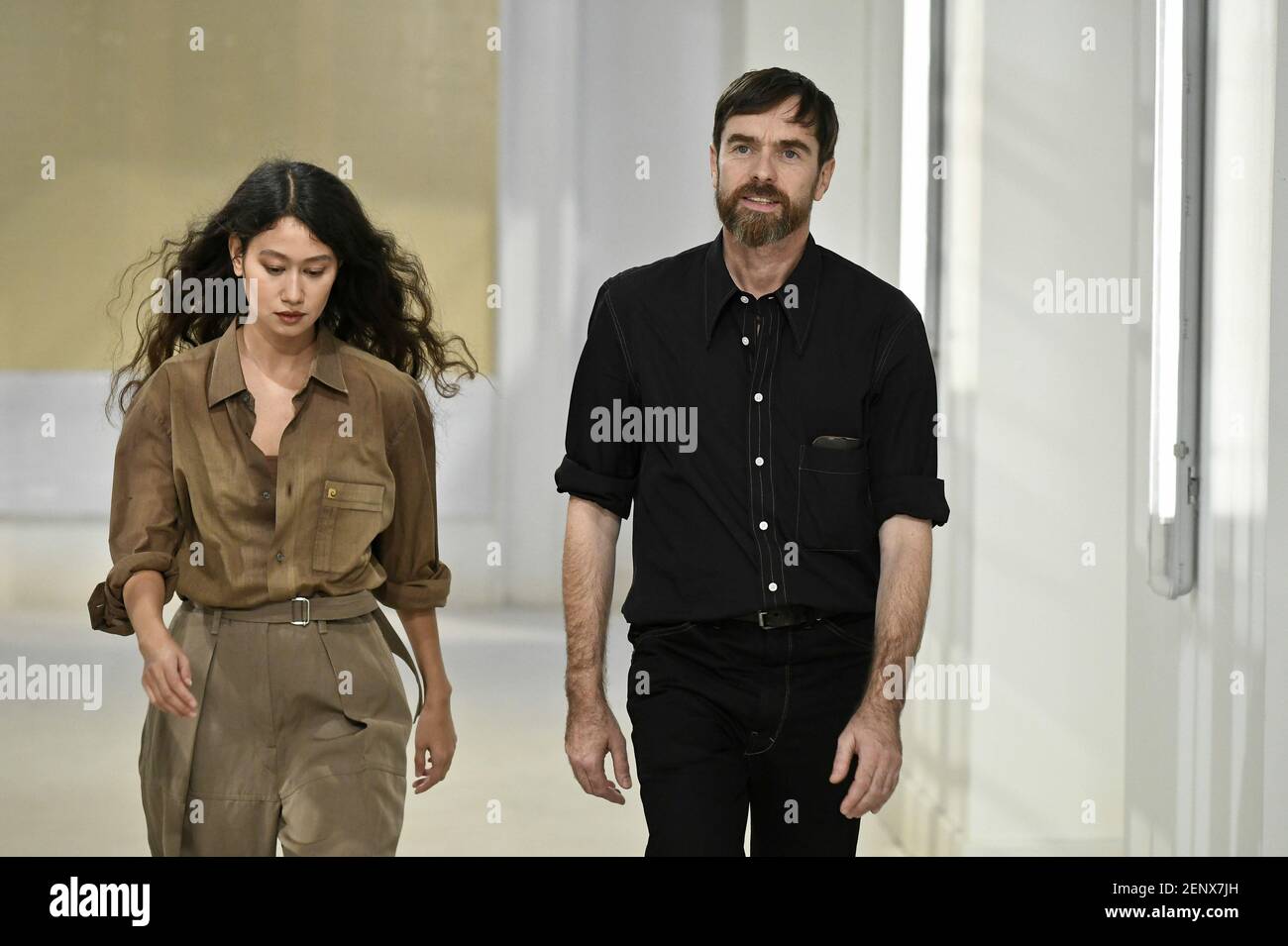 Designers Sarah-Linh Tran and Christophe Lemaire walking on the runway ...
