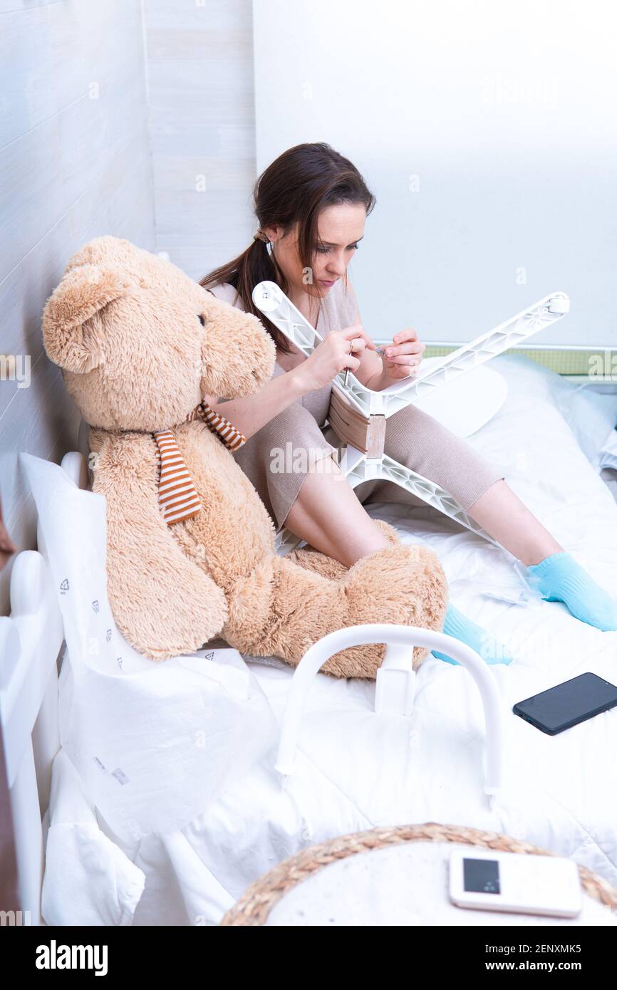 woman in home clothes mounting a baby feeding highchair. Furniture assembly. concept changes at home for baby Stock Photo